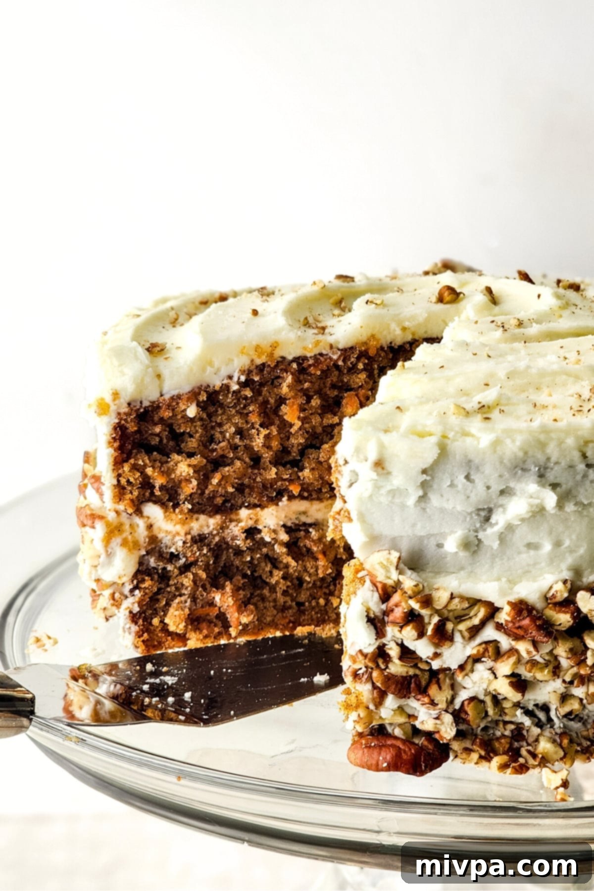 Gluten-Free Dairy-Free Carrot Cake A half-sliced gluten-free dairy-free carrot cake on cake stand.