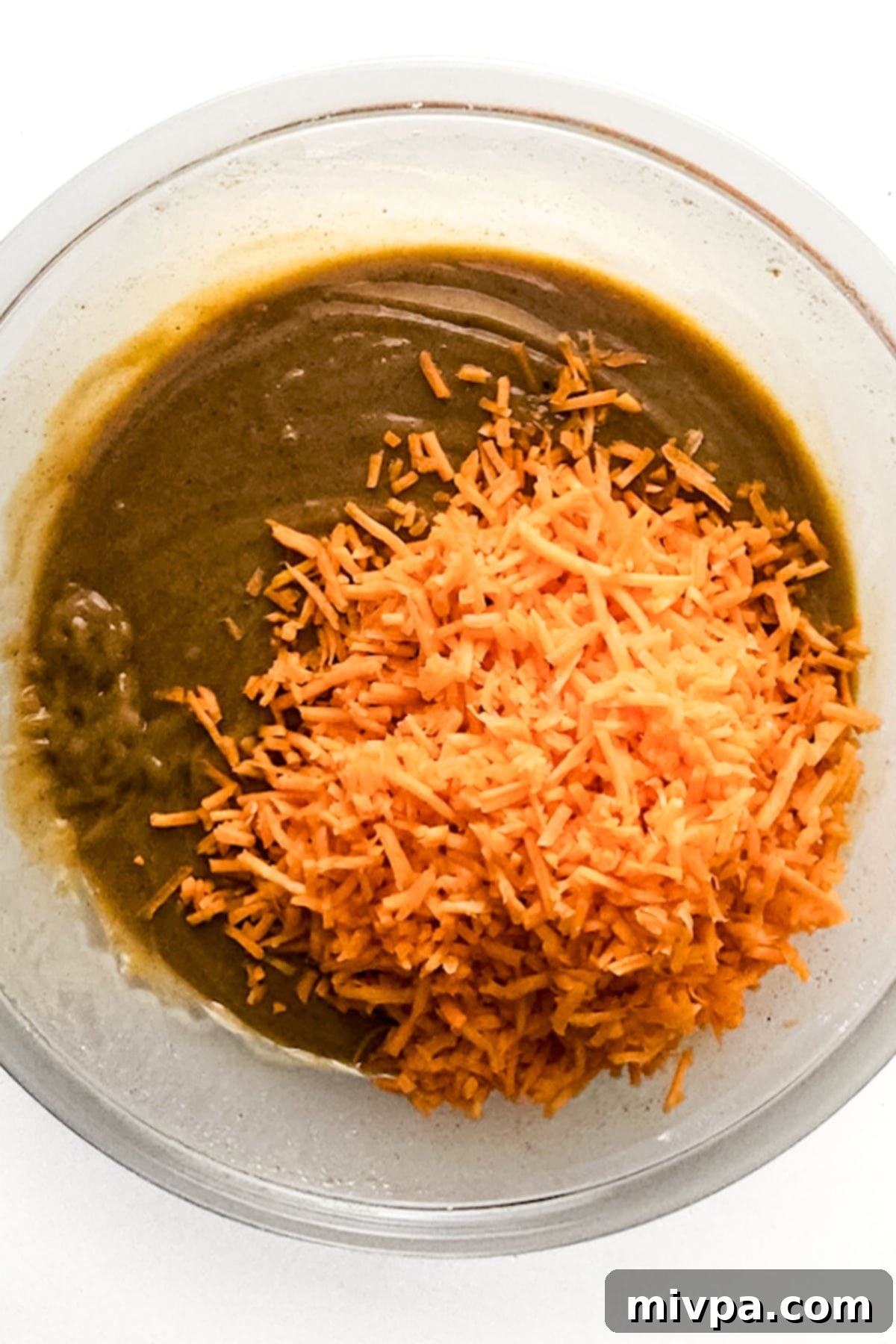 Moist Gluten-Free Carrot Cake (Dairy-Free) Shredded carrots on top of brown liquid mixture.