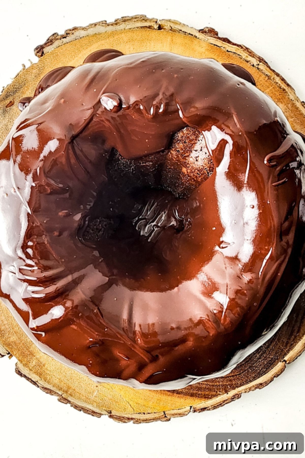 Ganache-covered chocolate bundt cake. Chocolate ganache poured over chocolate bundt cake.