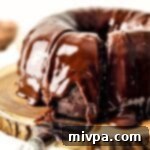 Fudgy Gluten Free Dairy Free Chocolate Bundt Cake 2 Gluten-free chocolate cake with ganache on wooden board.
