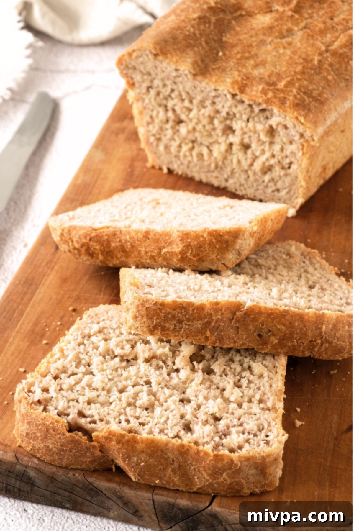 Gluten-Free Beer Bread (Dairy-Free) Sliced loaf of gluten-free beer bread on a rustic wooden board, showcasing its fluffy texture.