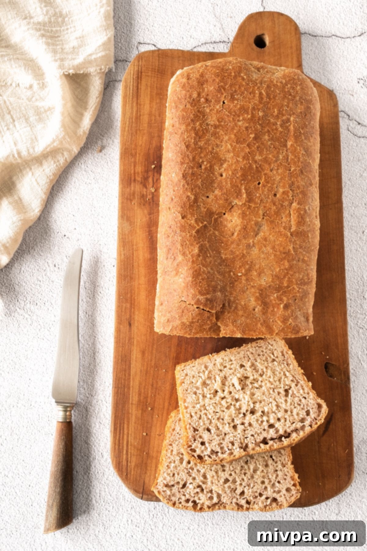 Gluten-Free Beer Loaf Top-down view of a delicious sliced gluten-free beer loaf on a wooden board, highlighting its airy crumb.