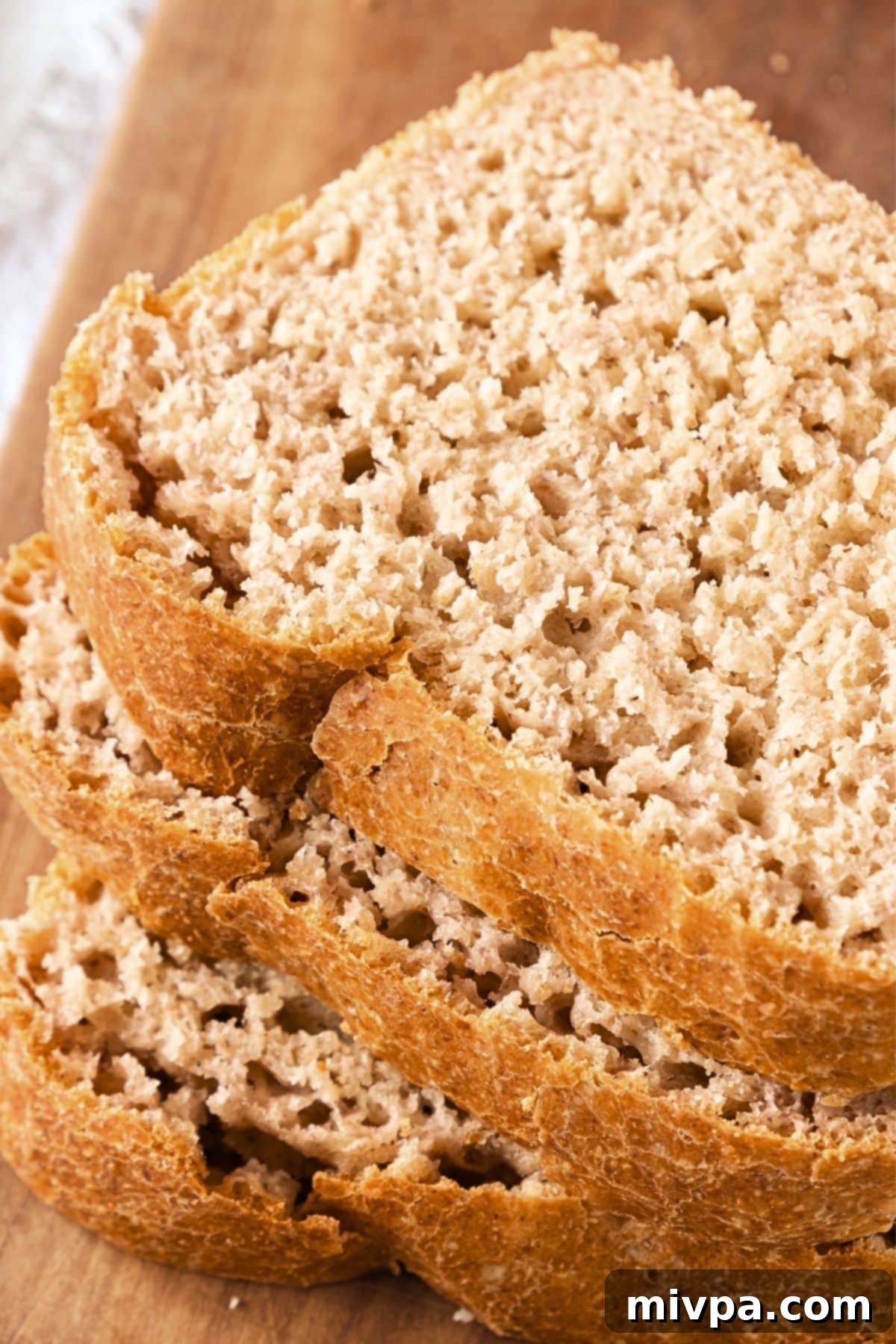 GF Beer Bread Recipe (Dairy-Free) Multiple slices of golden-brown gluten-free beer bread arranged on a wooden board.