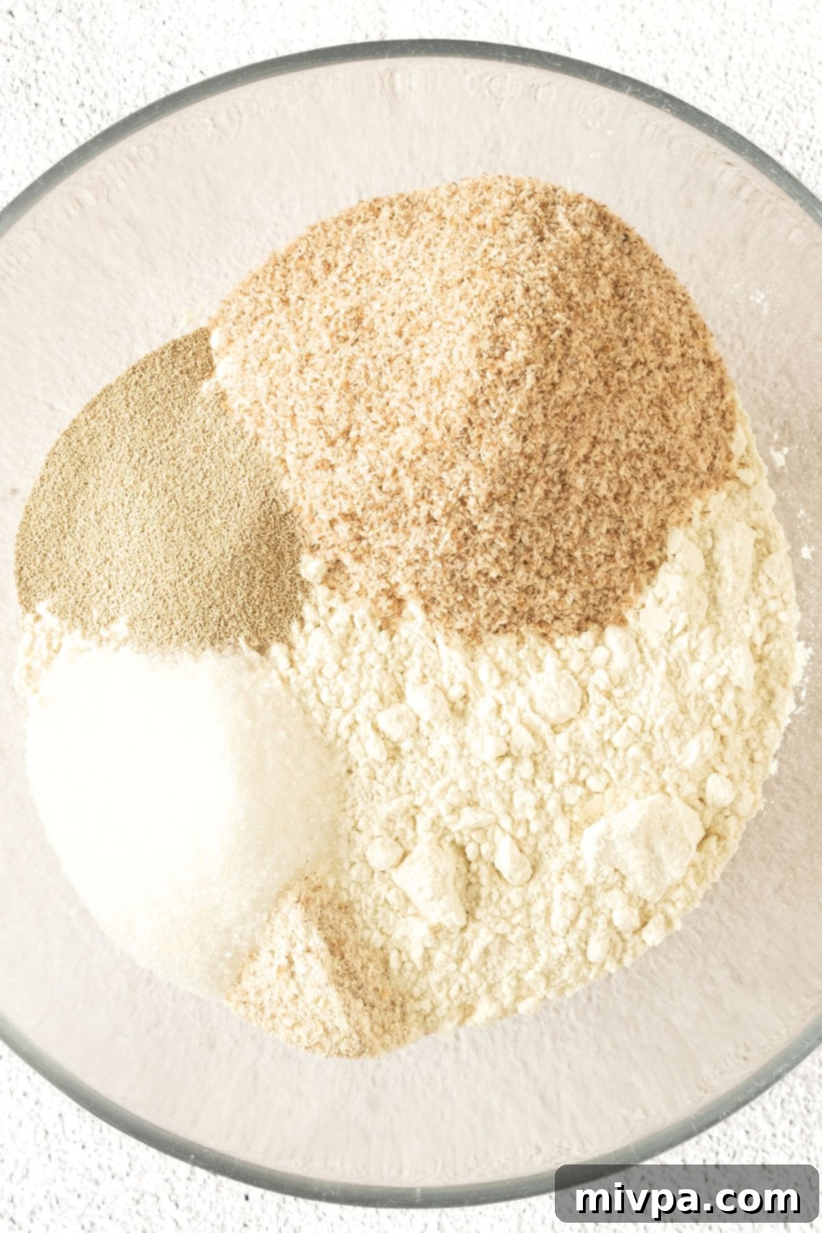 Gluten-Free Beer Bread Recipe Dry ingredients for gluten-free beer bread in a glass bowl, ready for mixing.