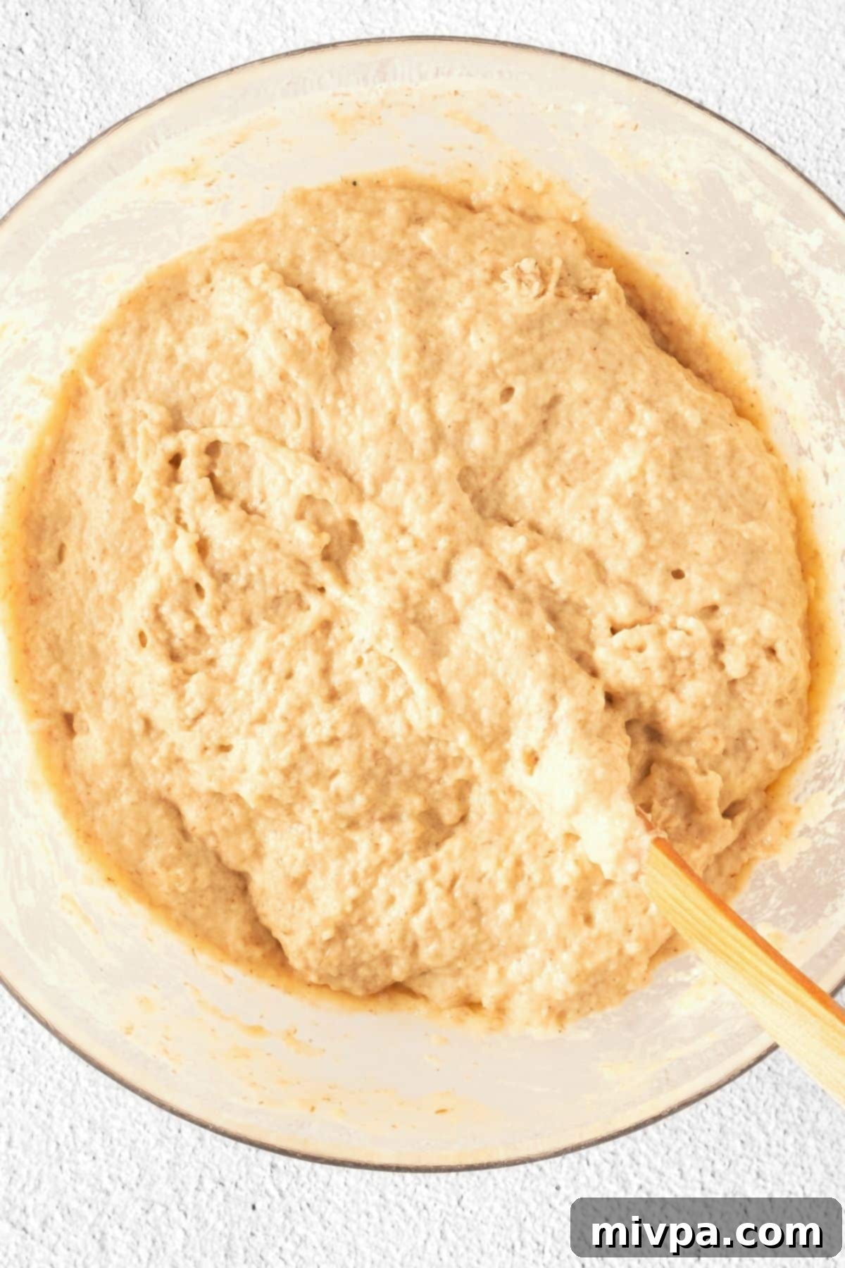 How to Make Gluten-Free Beer Bread Gluten-free beer bread dough in a glass bowl, showcasing its wet, cake-batter-like consistency.