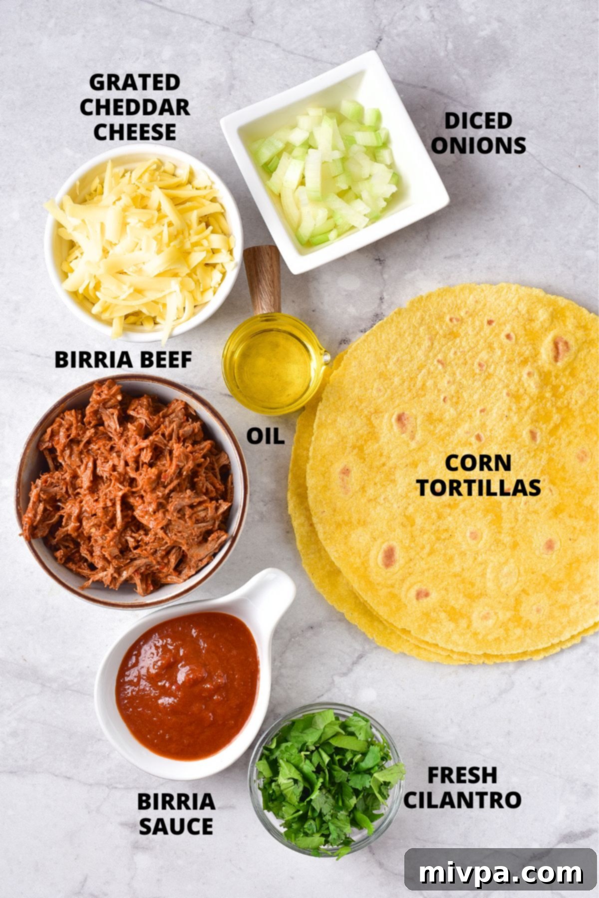 Ingredients for cheesy birria tacos recipe laid out on a marble board, including tortillas, cheese, beef, and toppings.