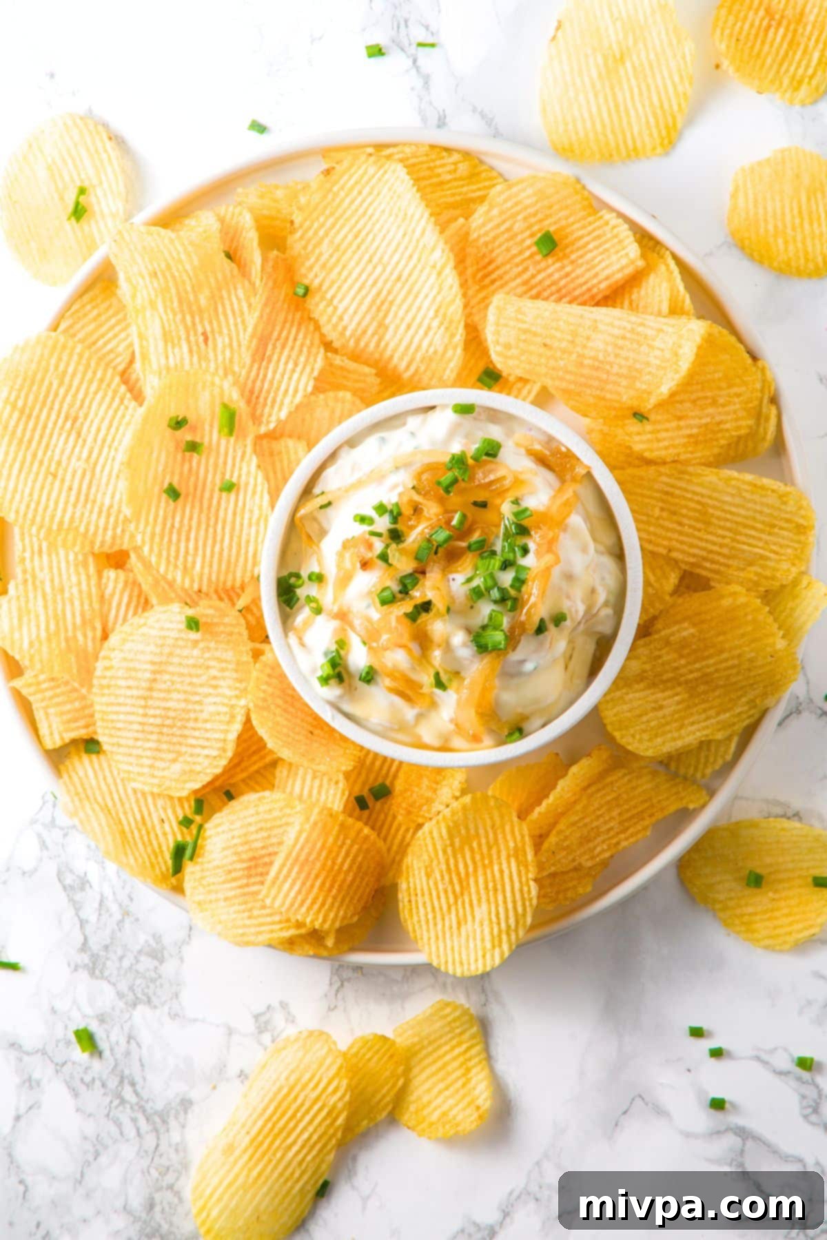 GF French Onion Dip Top down view of a big plate of chips and caramelized onion dip.
