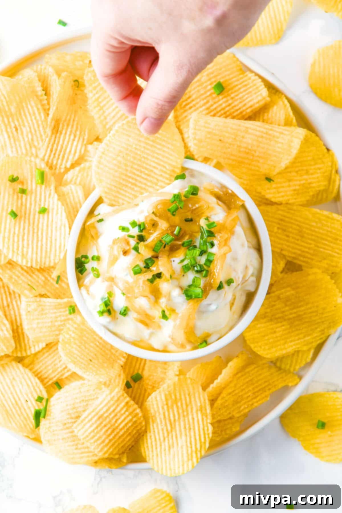 Homemade Gluten-Free Onion Dip Top down view of a bowl of gluten-free onion dip surrounded by chips.