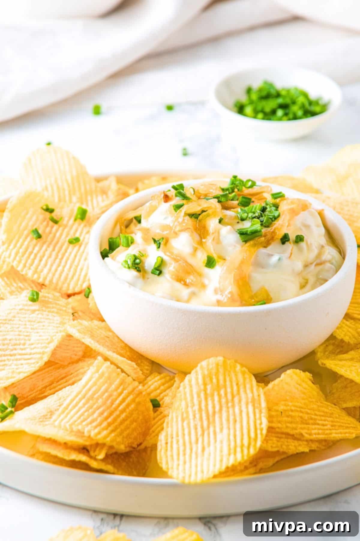 Easy Homemade French Onion Dip A plate of chips and onion dip.