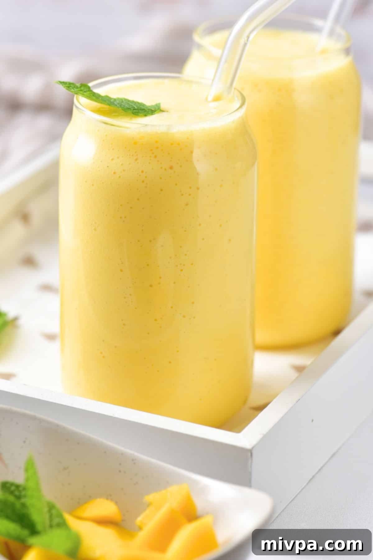 5-Ingredient Creamy Mango Milk Shake Up close shot of easy mango milk shake in glasses, showcasing its creamy texture and vibrant color.