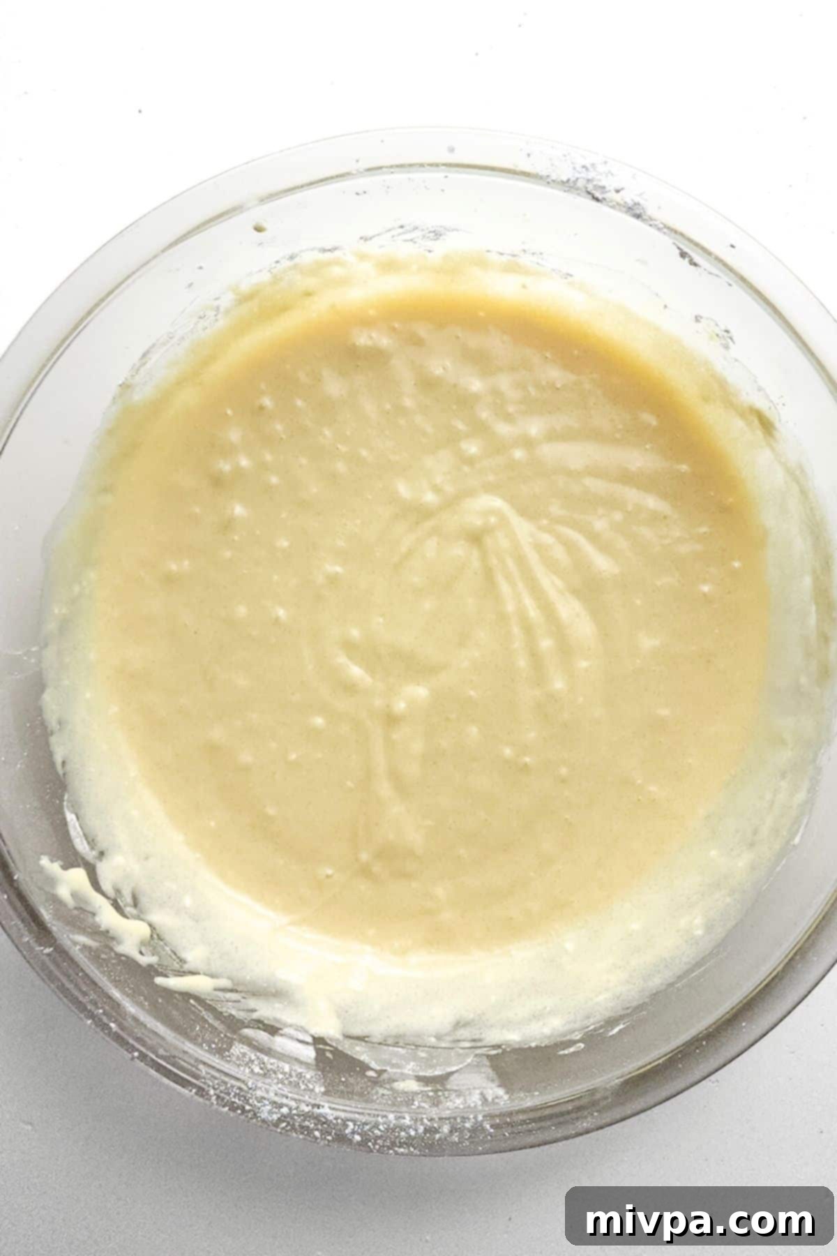 Gluten-Free Crumble Cake Batter Smooth, pale yellow cake batter resting in a clear glass bowl, perfectly mixed and ready for the next step.