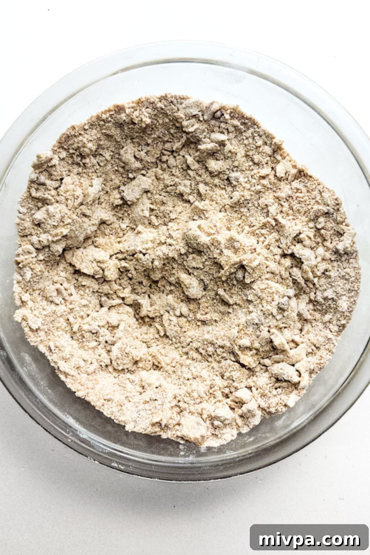 Easy Gluten-Free Crumble Cake Streusel Mixture The streusel mixture with cubed cold butter being blended by a fork in a bowl, forming delicious crumbs.