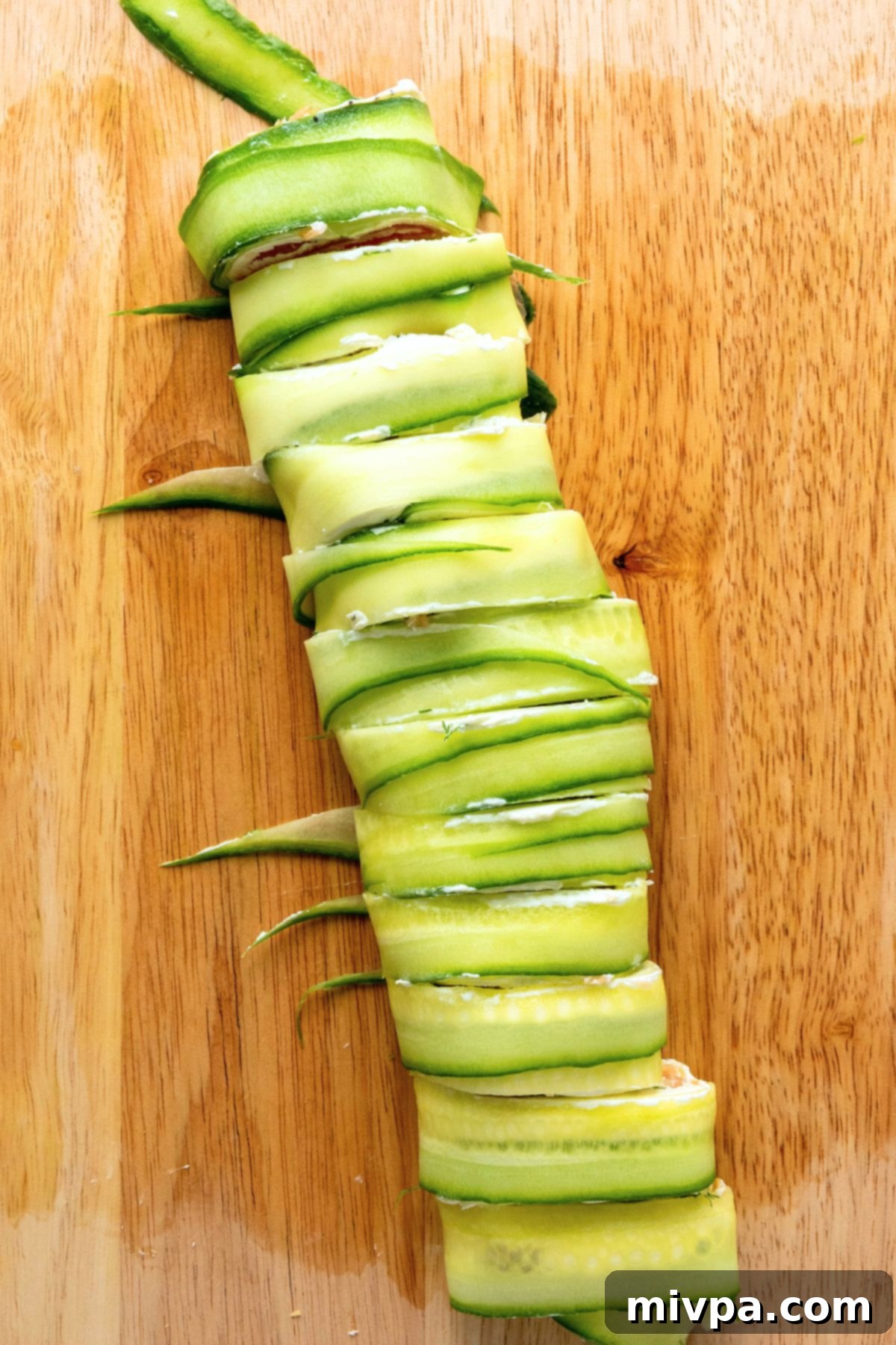Easy Cucumber Roll Recipe Slice cucumber roll on wooden board
