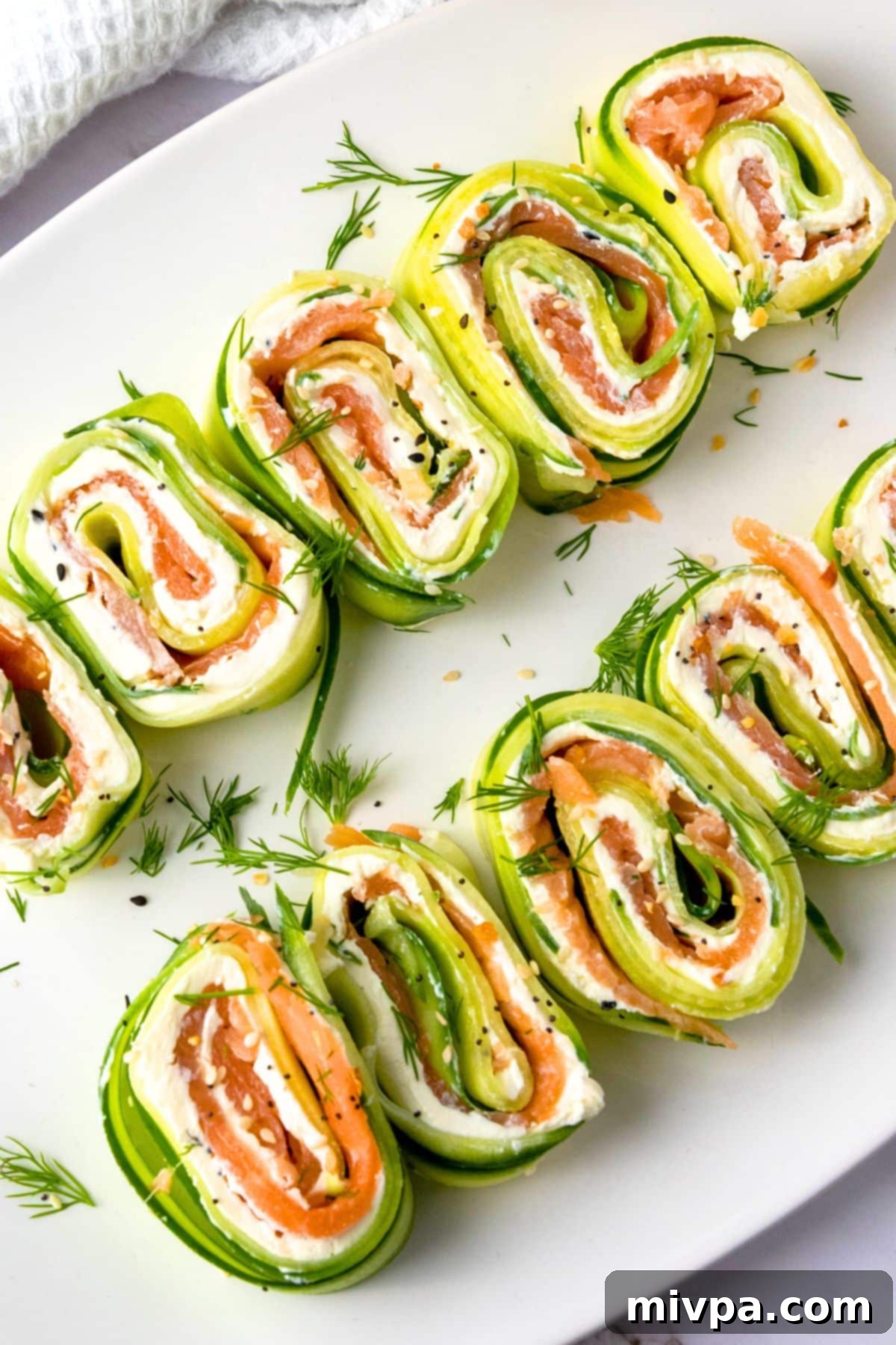 Easy Cucumber Rolls Top down view of a plate of cucumber cream cheese roll ups