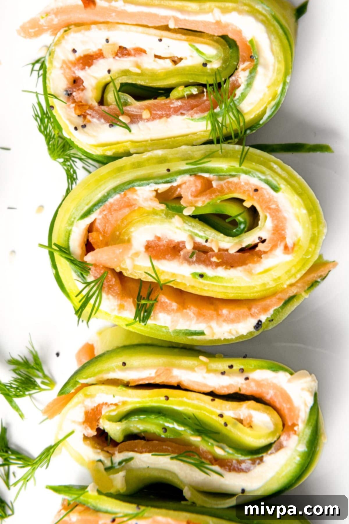 Cucumber Salmon Roll Ups Top down view of cucumber salmon roll ups on plate.