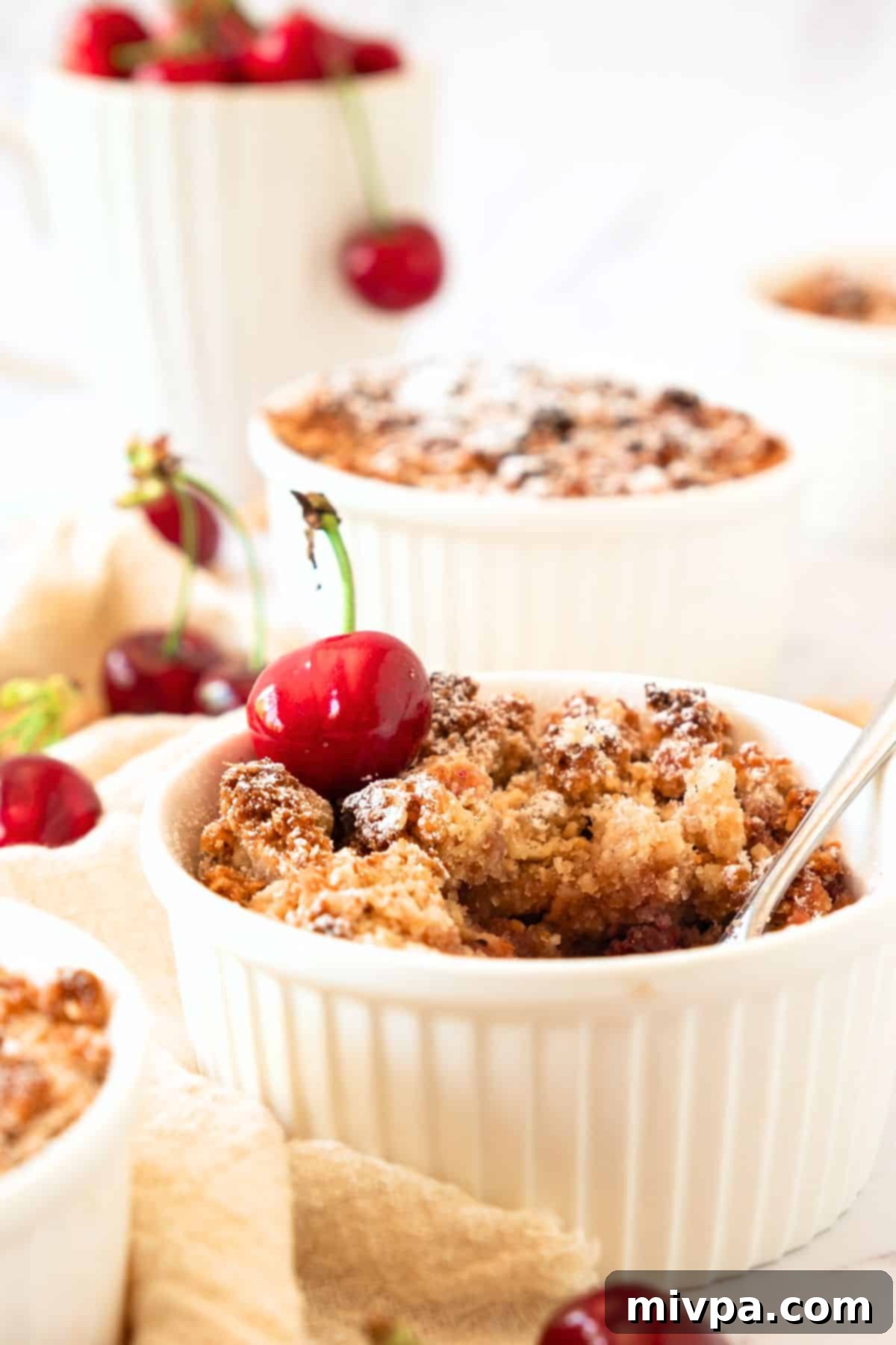 Gluten-Free Cherry Crumble (Vegan) Individual ramekins filled with golden-brown gluten-free cherry crumble, ready to serve.