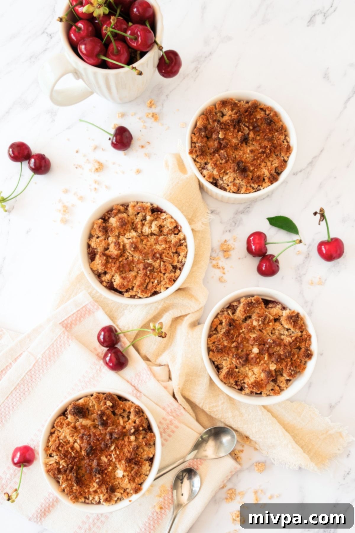 Easy Cherry Crumble (Gluten-Free, Vegan) Freshly baked cherry crumbles in ramekins, bubbling with juicy filling and a perfectly golden-brown topping.