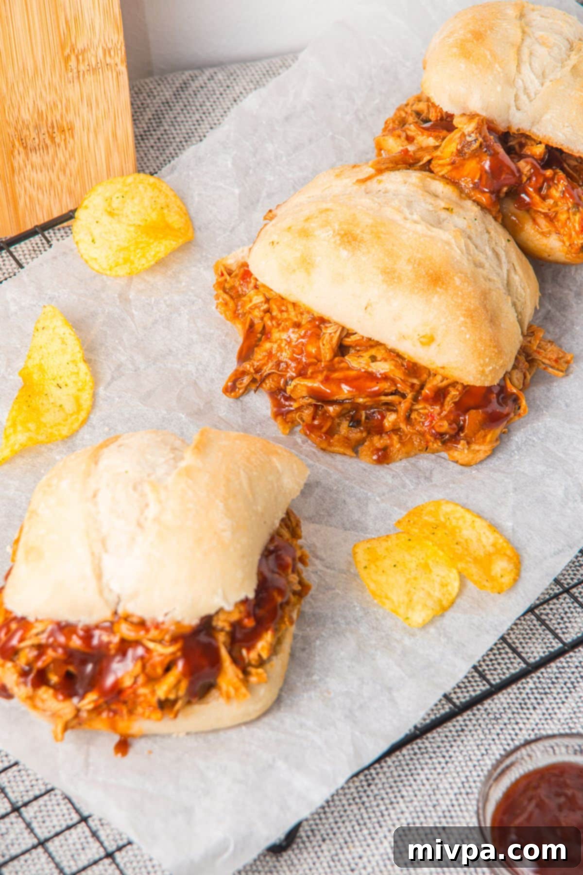 GF pulled pork sandwiches on parchment paper.