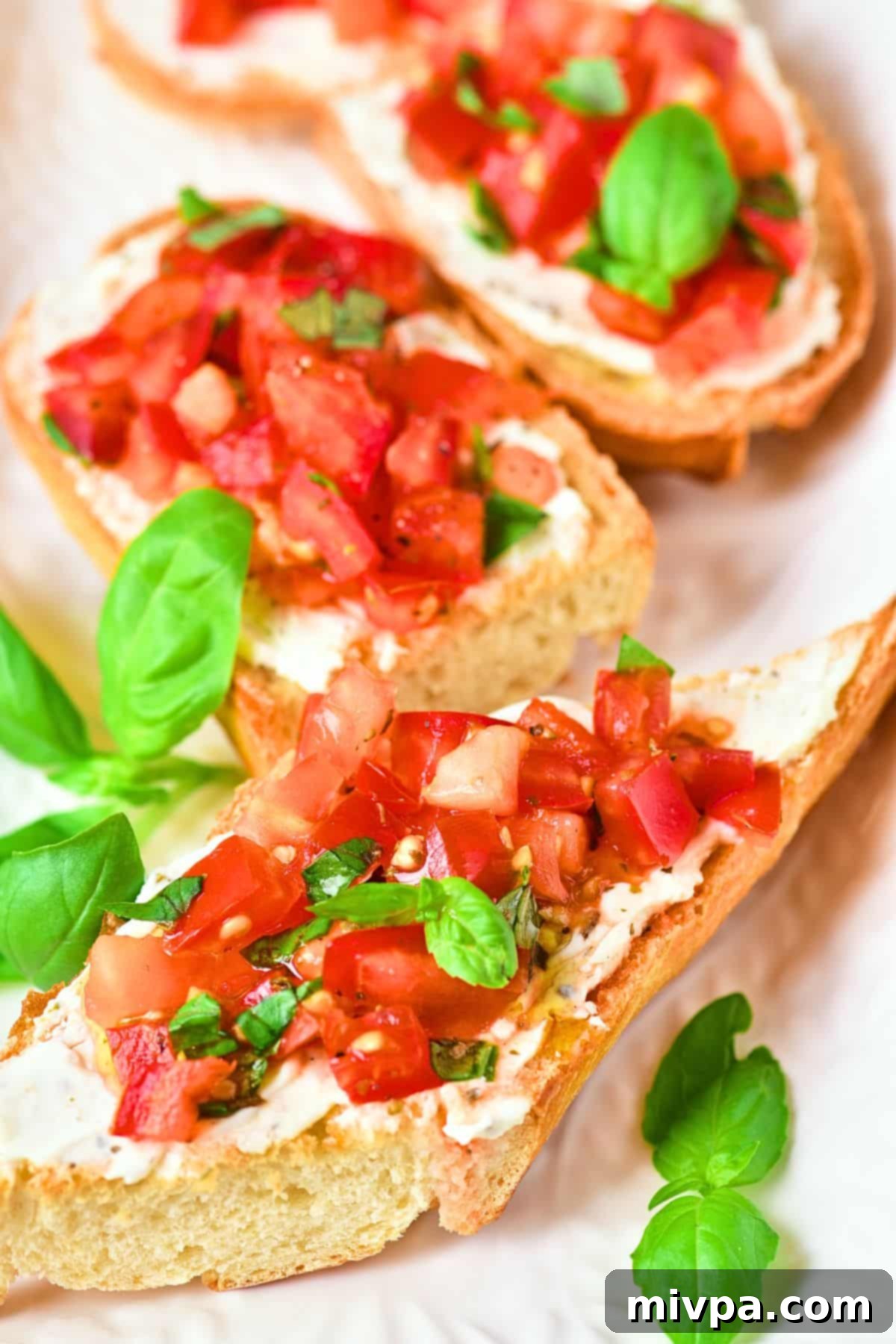 Easy Gluten-Free Bruschetta (Vegan) Up close view of gluten-free bruschetta garnished with basil leaves.