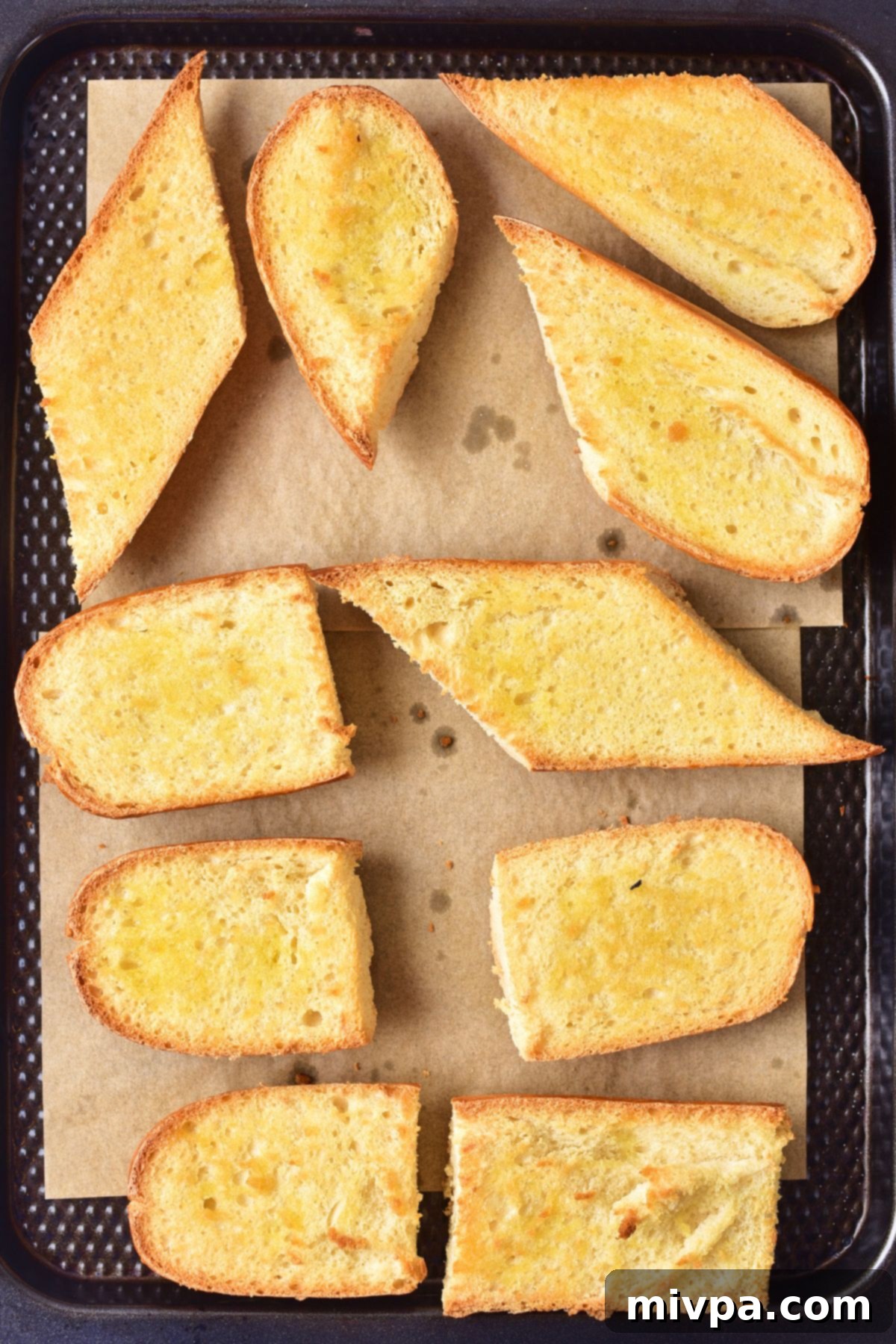 How to Make Bruschetta Toasted baguette slices on parchment-lined baking sheet.
