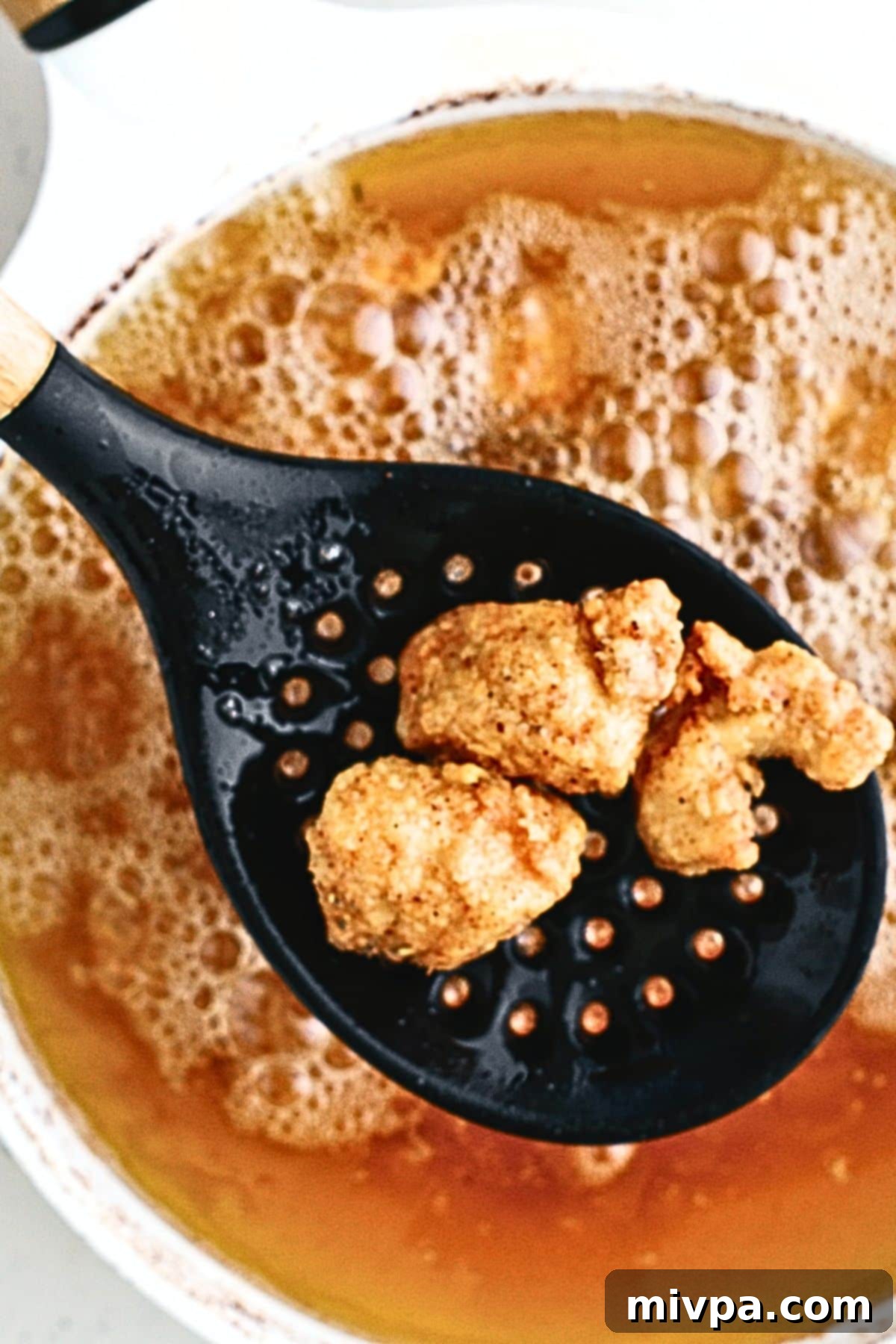 Deep frying breaded chicken.