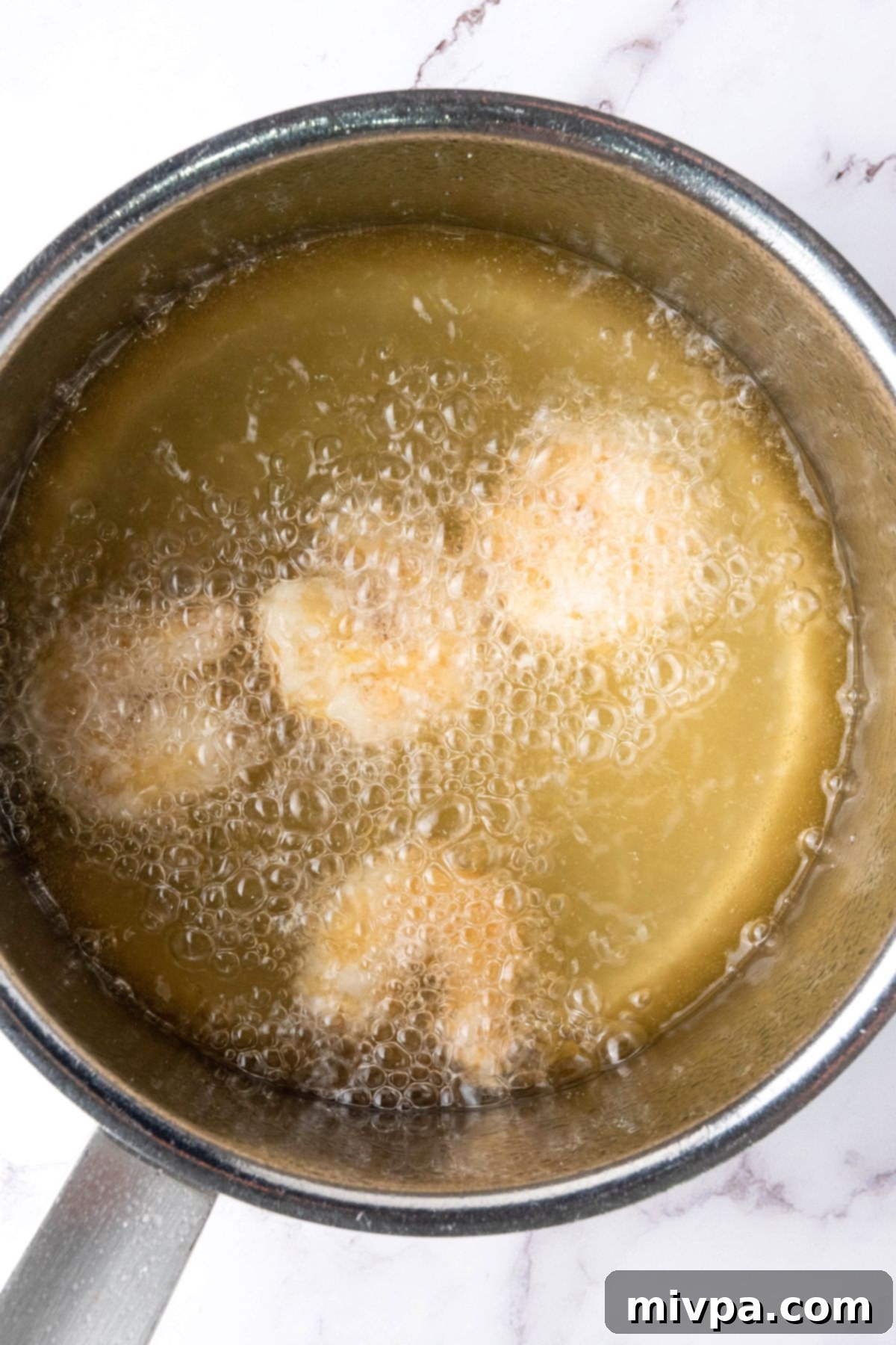 Easy Gluten-Free Fried Shrimp Deep frying shrimp in a pot of oil.