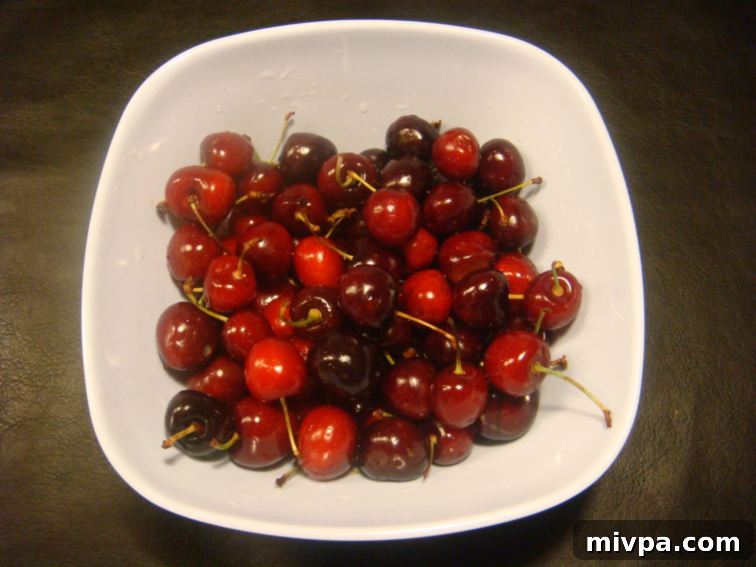 Chocolate Cherry Muffins 4 A bowl of vibrant, red fresh cherries, washed and ready for preparation.