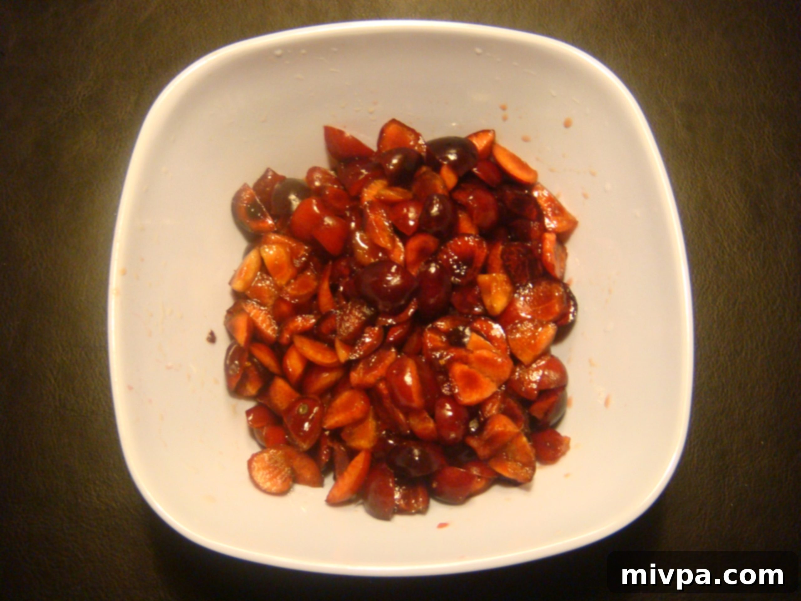 Close-up of fresh cherries, meticulously de-seeded and cut into small, even pieces, ready to be incorporated into the muffin batter.
