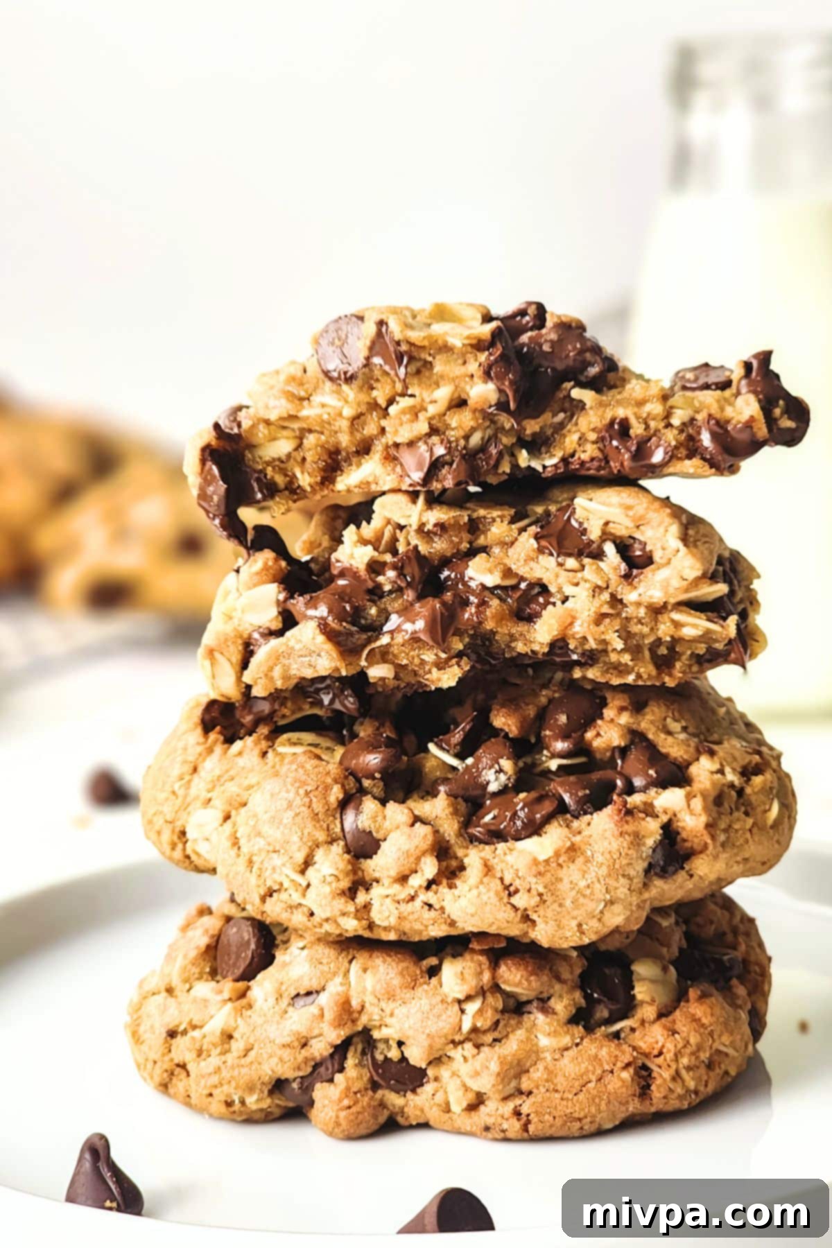 Chewy Gluten-Free Chocolate Chip Oatmeal Cookies A stack of perfectly baked gluten-free chocolate chip oatmeal cookies, highlighting their soft texture and abundant chocolate chips.