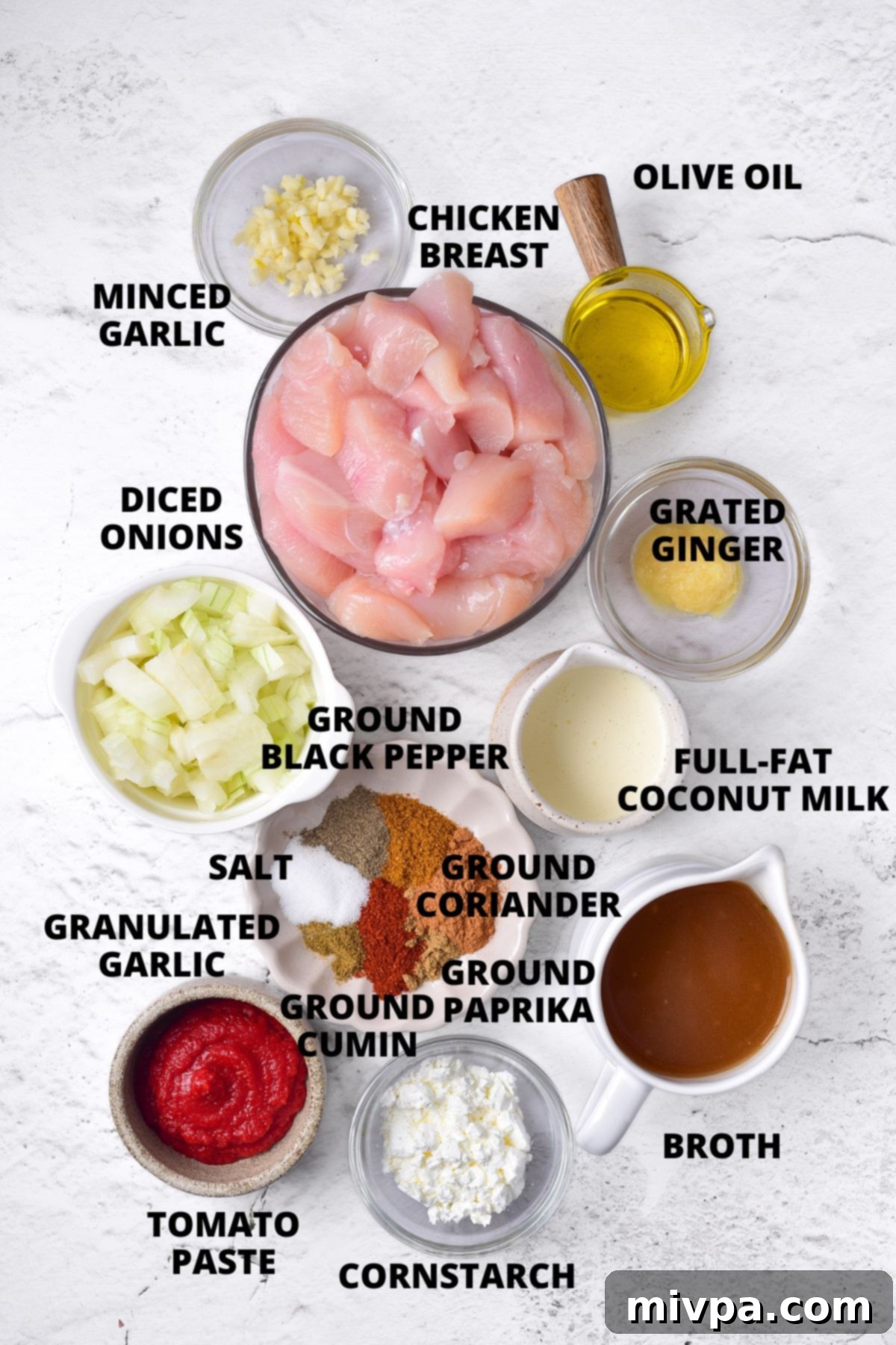 Ingredients for gluten-free chicken curry recipe laid out on marble board.