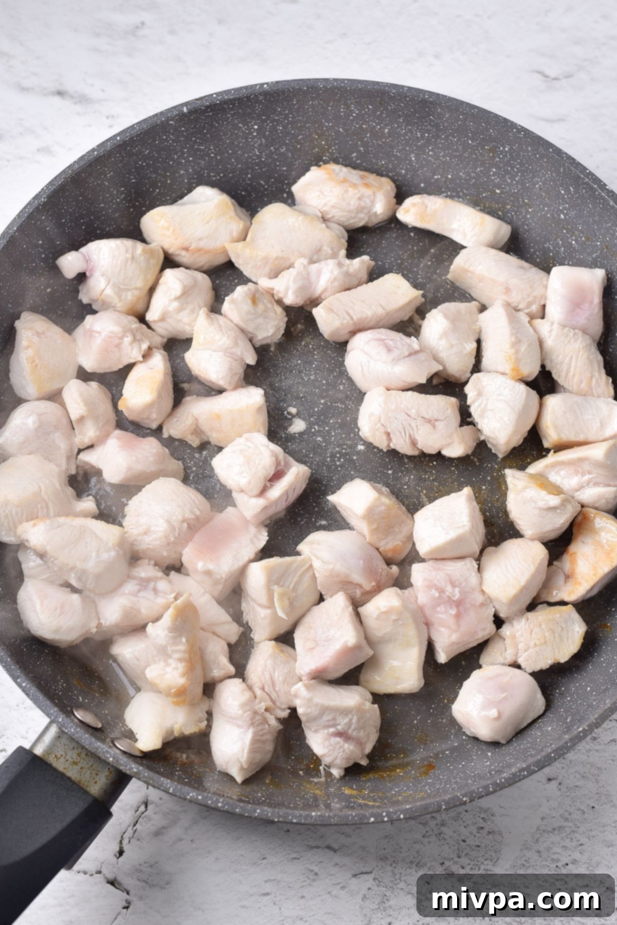 Sautéing chicken cubes in skillet.