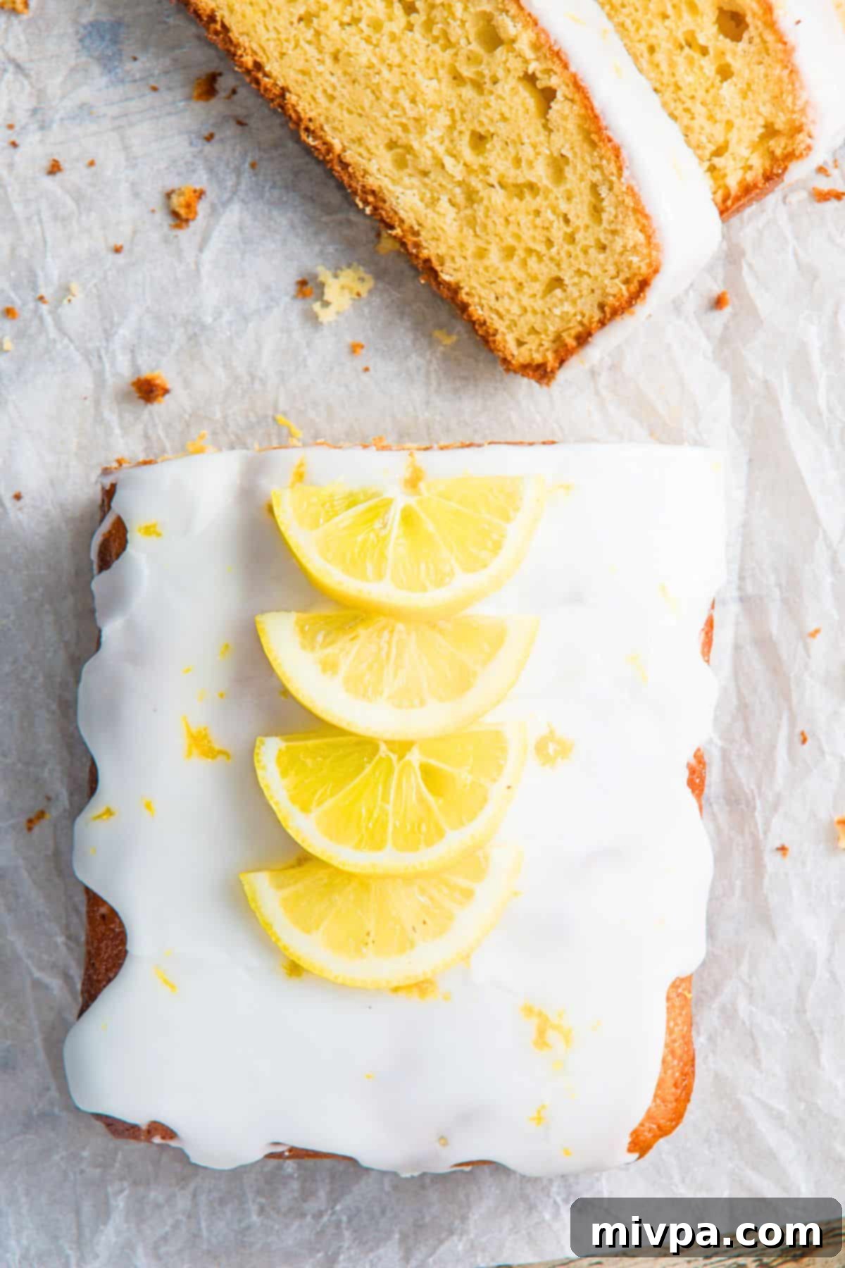 Gluten-Free Dairy-Free Lemon Drizzle Cake Half-sliced loaf of lemon drizzle cake (gluten free) on a wire rack, ready to be served.