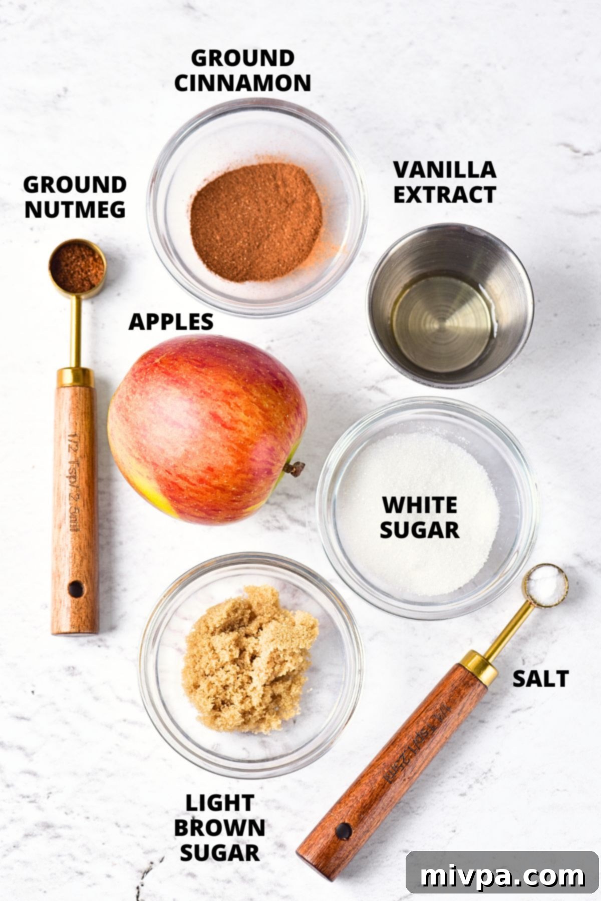 Ingredients for homemade apple butter recipe laid out on marble board.