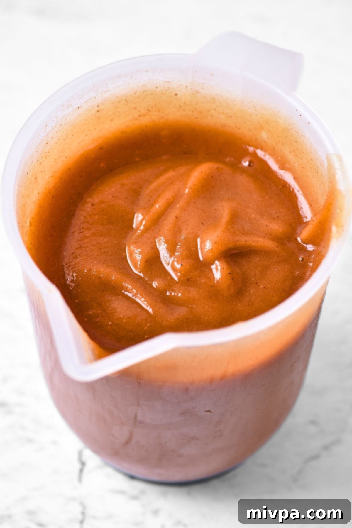 Pureed apple butter in a measuring cup