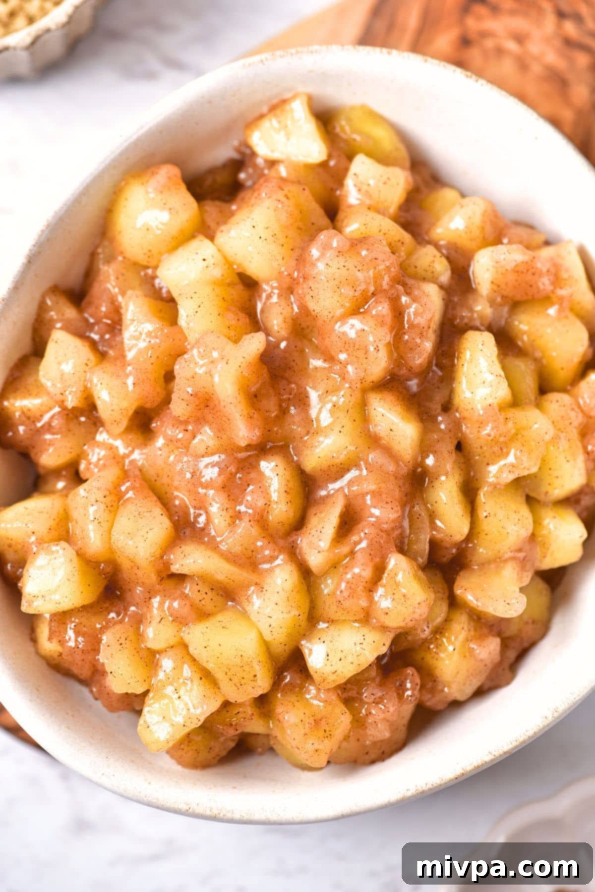 Top down view of a freshly made bowl of apple pie filling, perfectly cooked and ready to be incorporated into a dessert or stored.