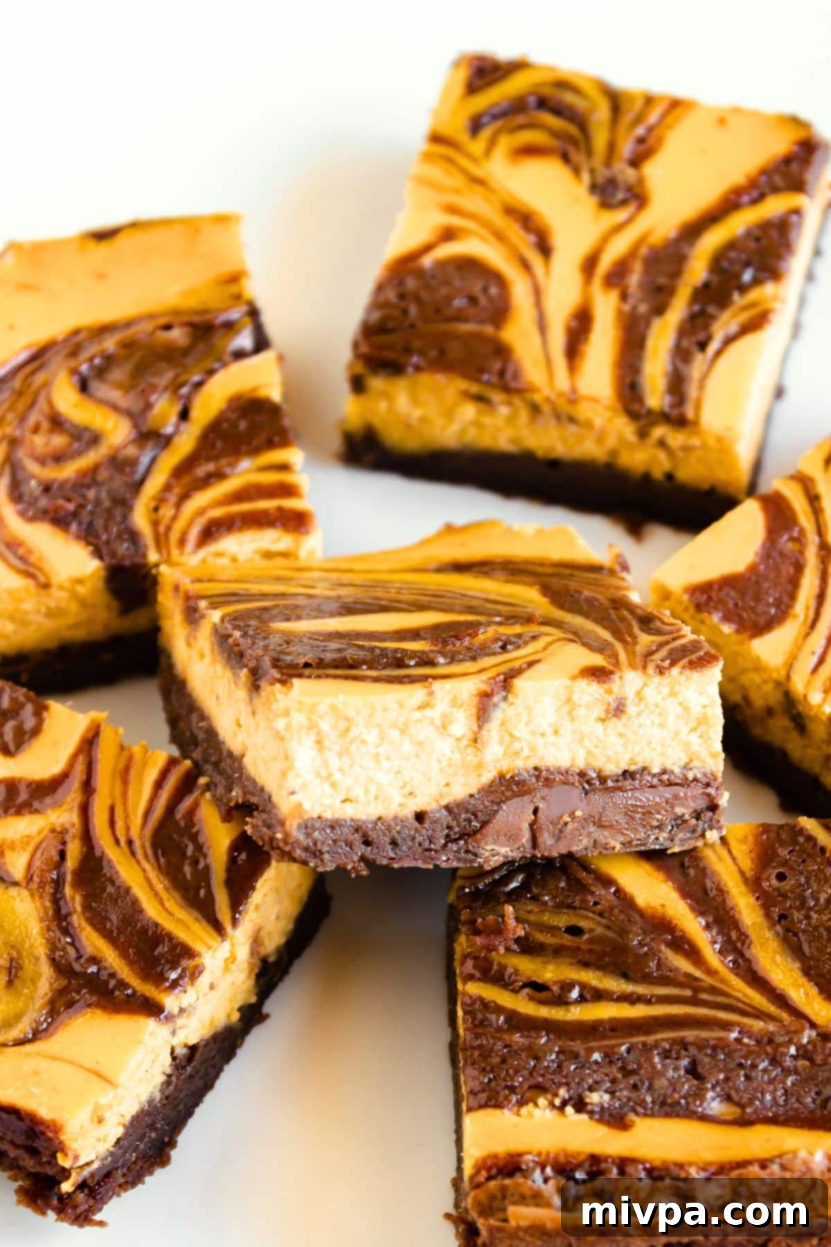 Marbled Pumpkin Cheesecake Brownies (Gluten-Free, Dairy-Free) Up close shot of beautifully marbled pumpkin cheesecake brownies, highlighting the distinct layers.