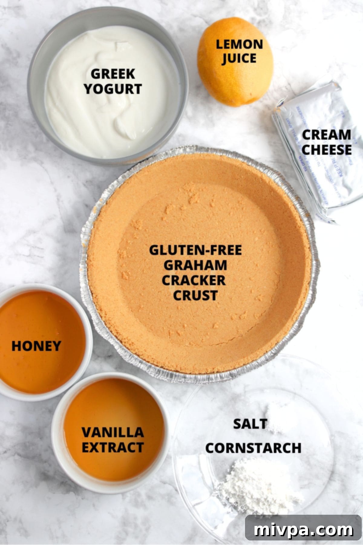 All the ingredients for the greek yogurt cheesecake recipe beautifully laid out on a marble board.