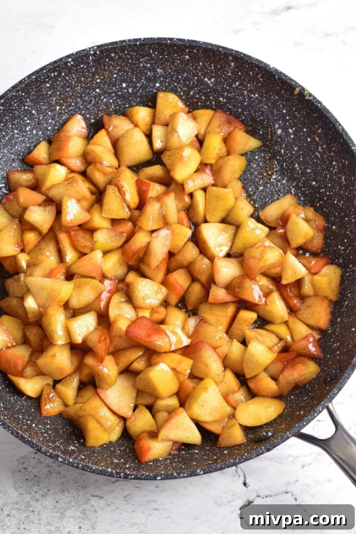 Easy Caramelized Apples (Gluten-Free, Vegan) A skillet with caramelized cinnamon apples