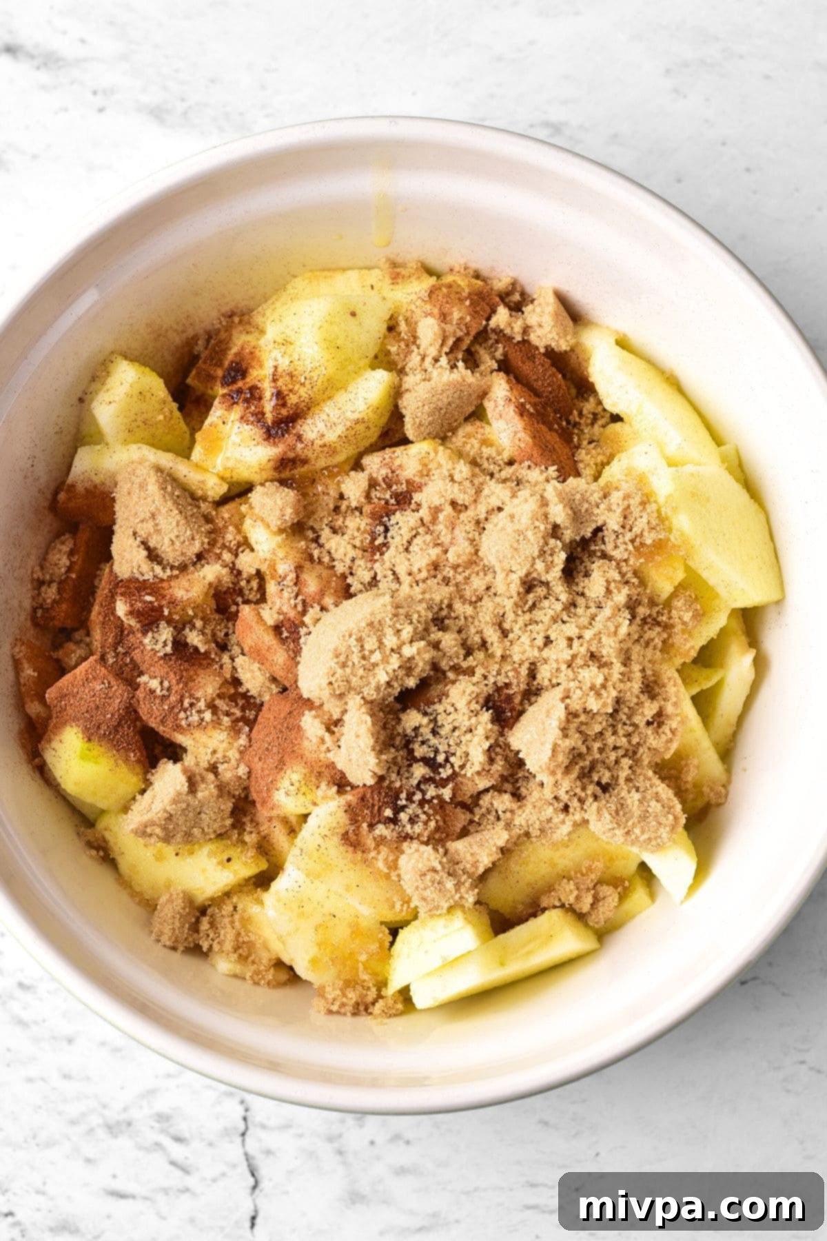 Brown sugar and cinnamon sprinkled on top of sliced apples