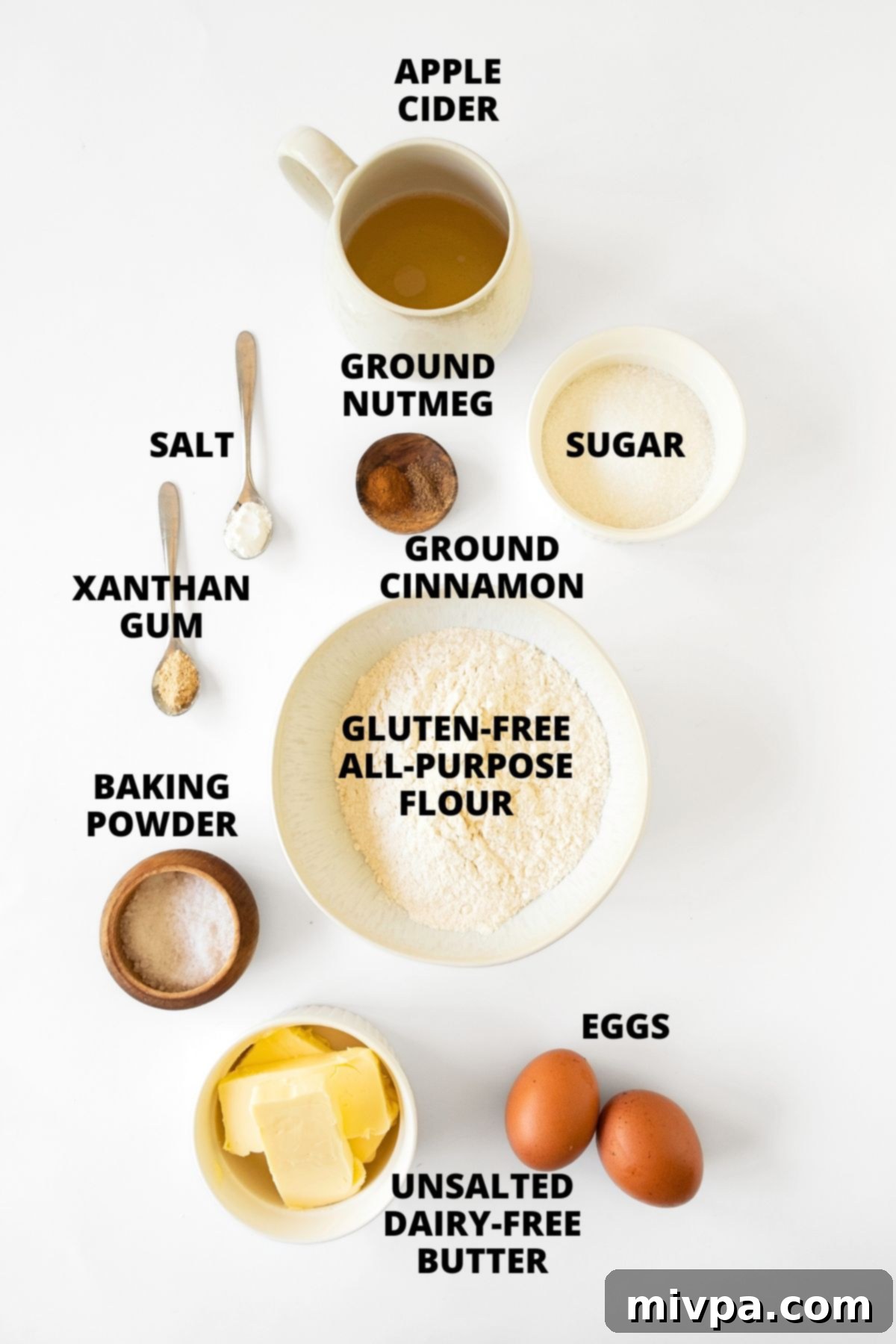 Ingredients for gluten-free apple cider donuts recipe laid out on white board.
