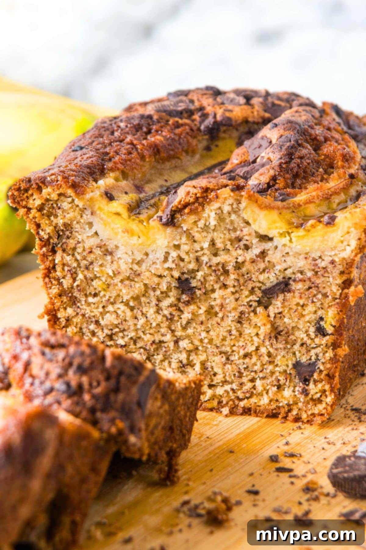 Half-sliced loaf of chocolate chip banana bread (gluten-free).