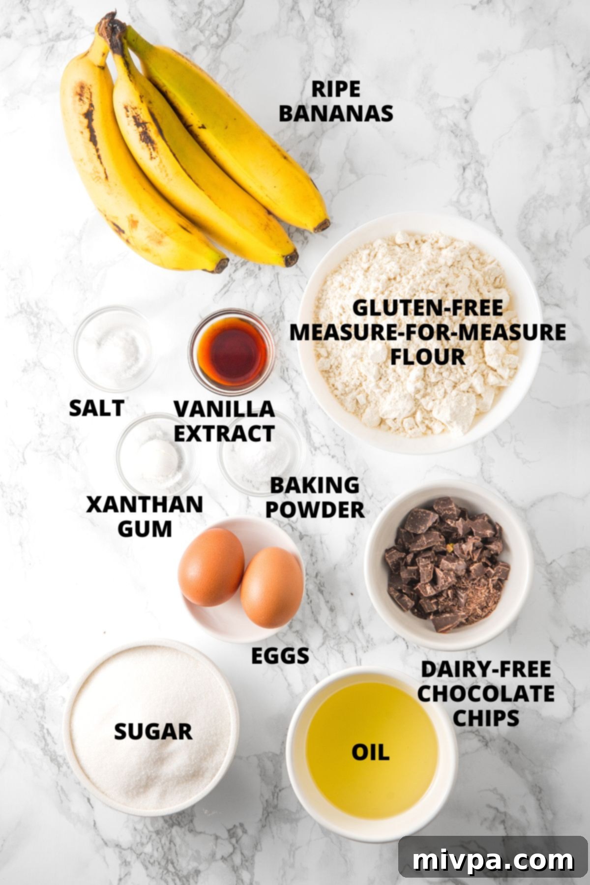 Ingredients for chocolate chip banana bread recipe laid out on marble board.