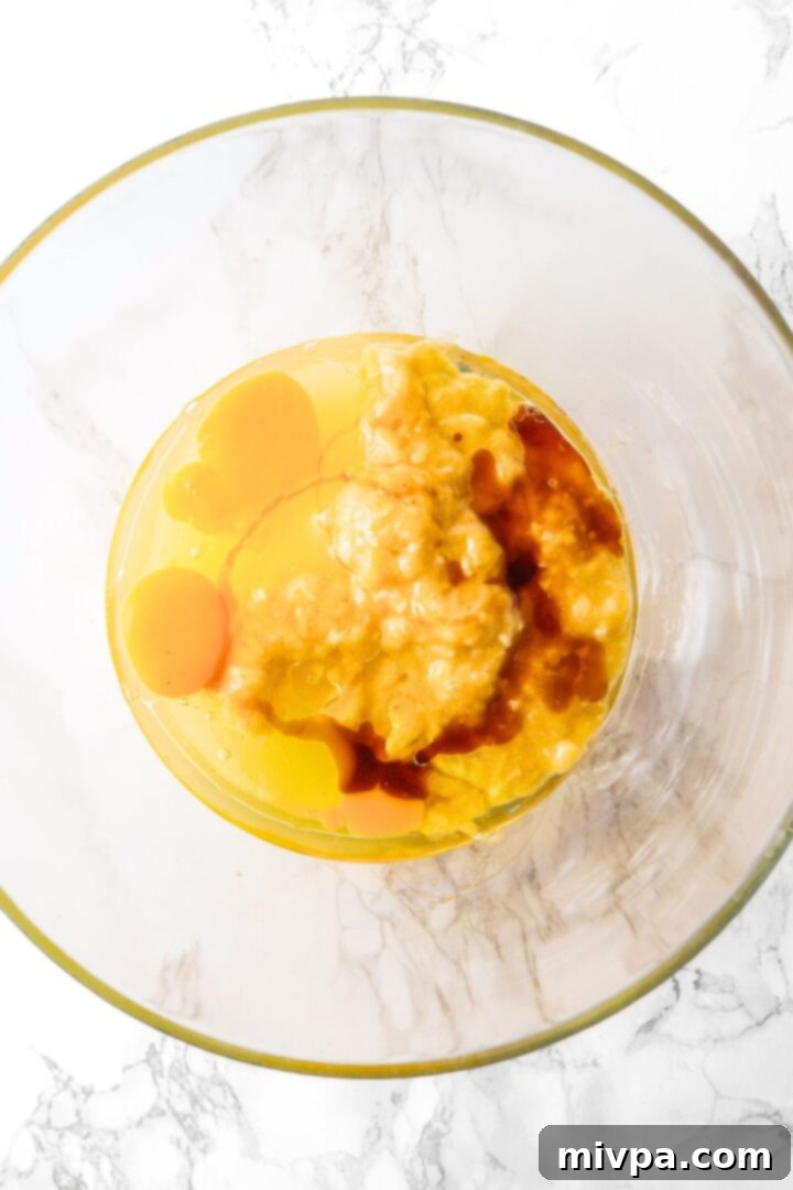 Mixing eggs, sugar and wet ingredients in a bowl.