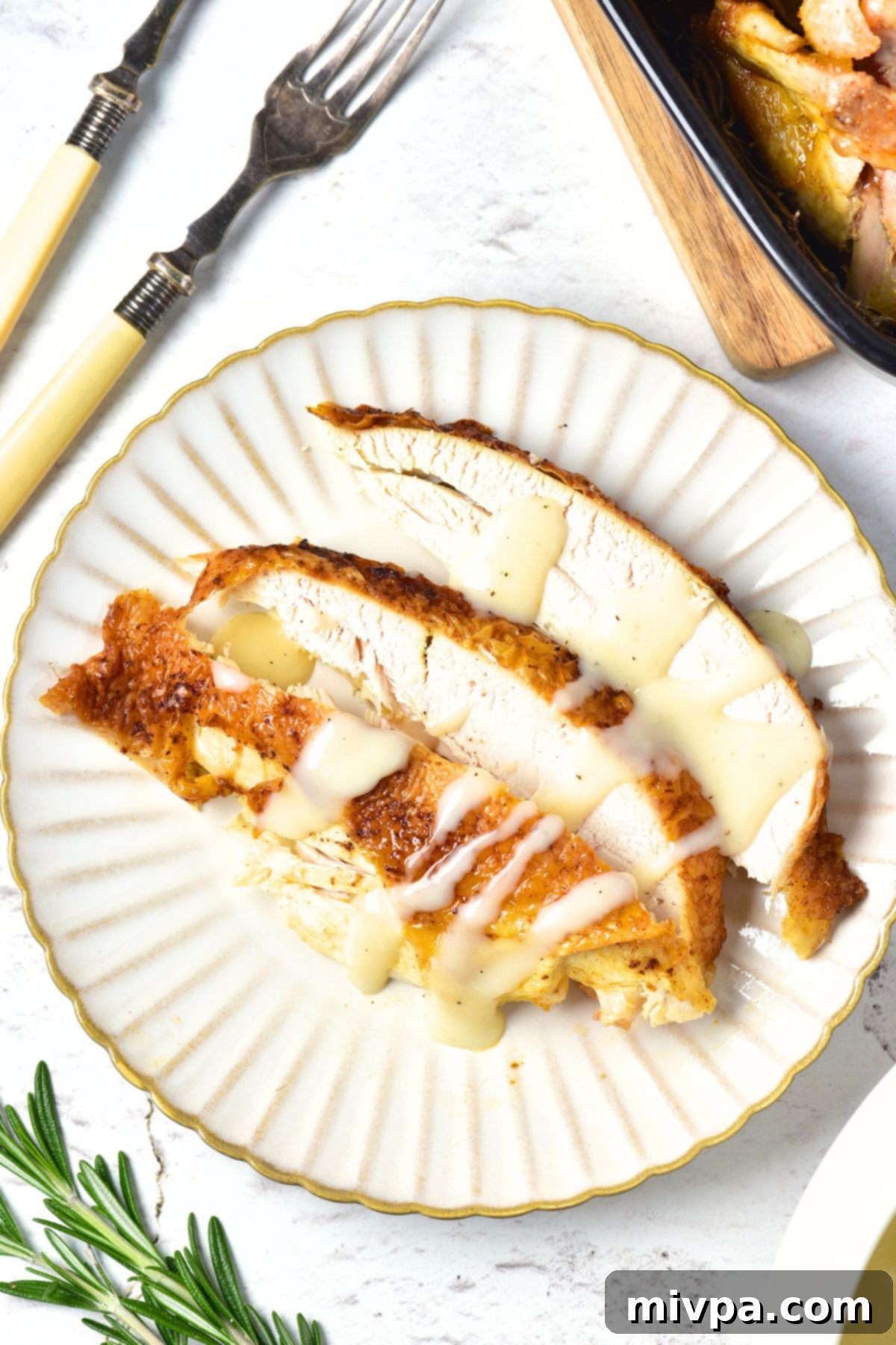 Top down view of chicken breast slices drizzled in chicken gravy.