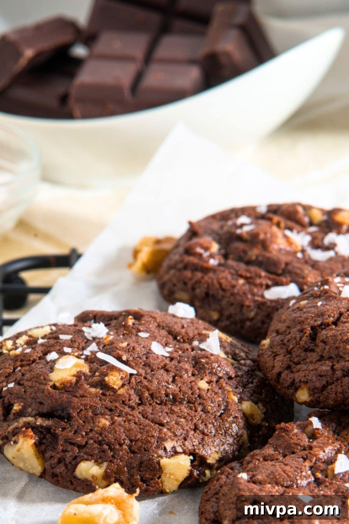 Close-up of Chocolate Cookies with Walnuts An up-close, enticing image of a cooling chocolate cookie adorned with walnuts, showcasing its texture.