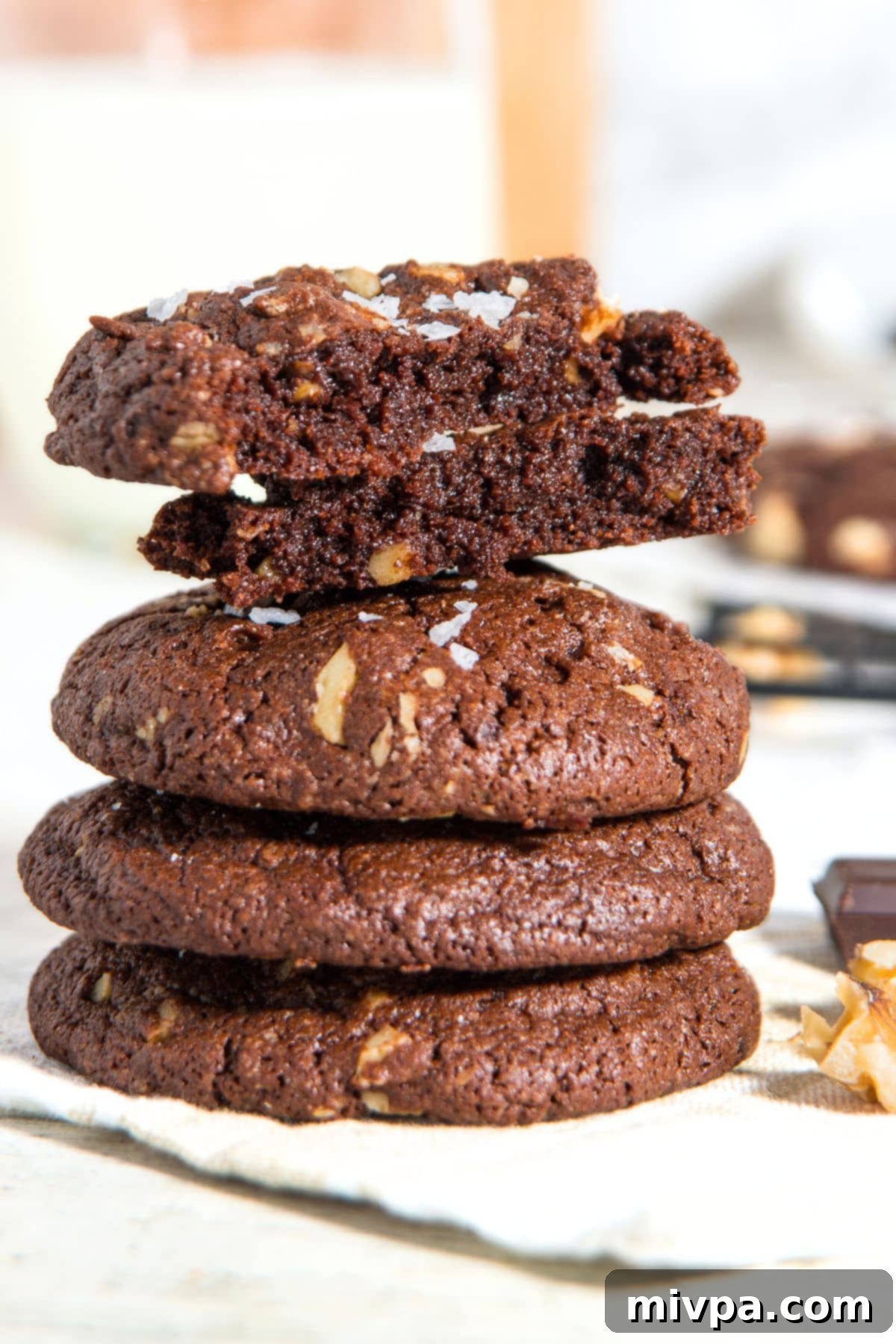 Delicious Gluten-Free Dairy-Free Chocolate Walnut Cookies A stack of half-eaten chocolate walnut cookies, showcasing their chewy interior and nutty texture.