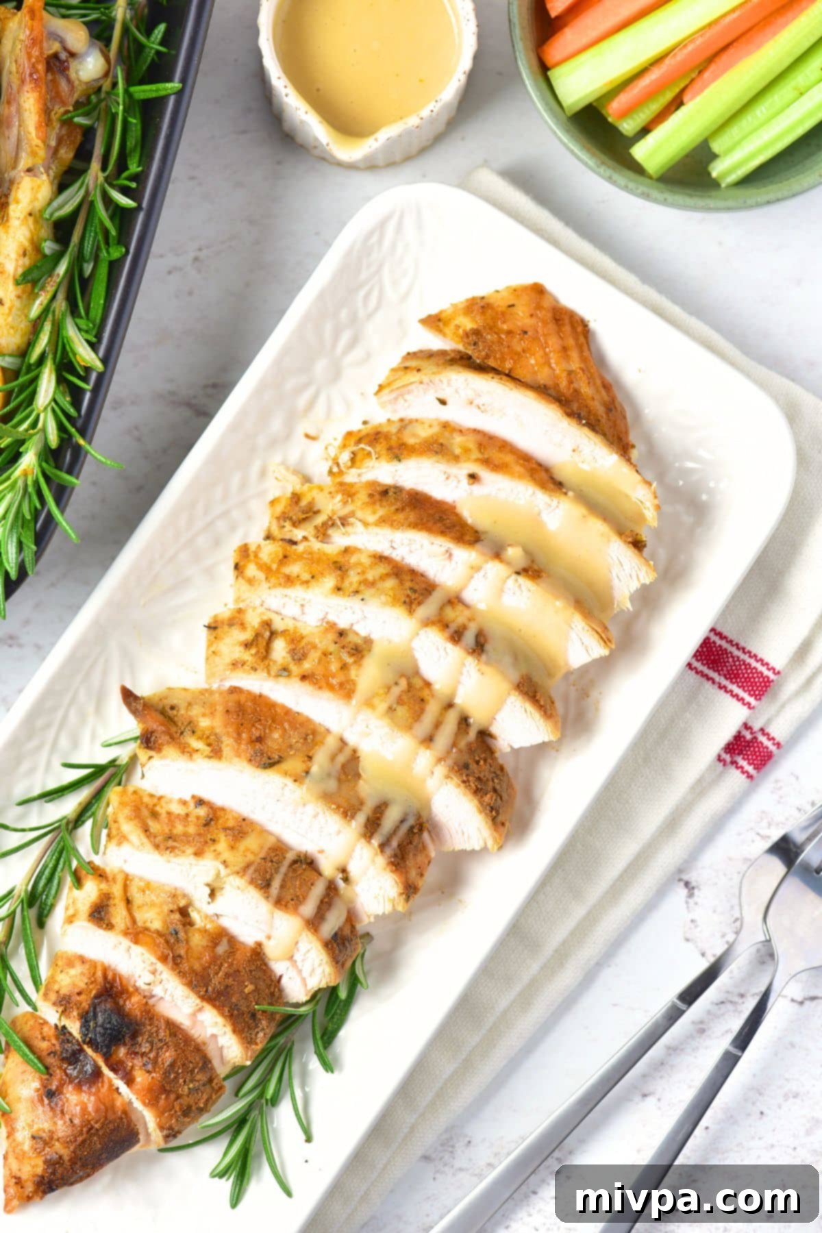 Top down view of sliced roasted turkey breast drizzled in gravy.