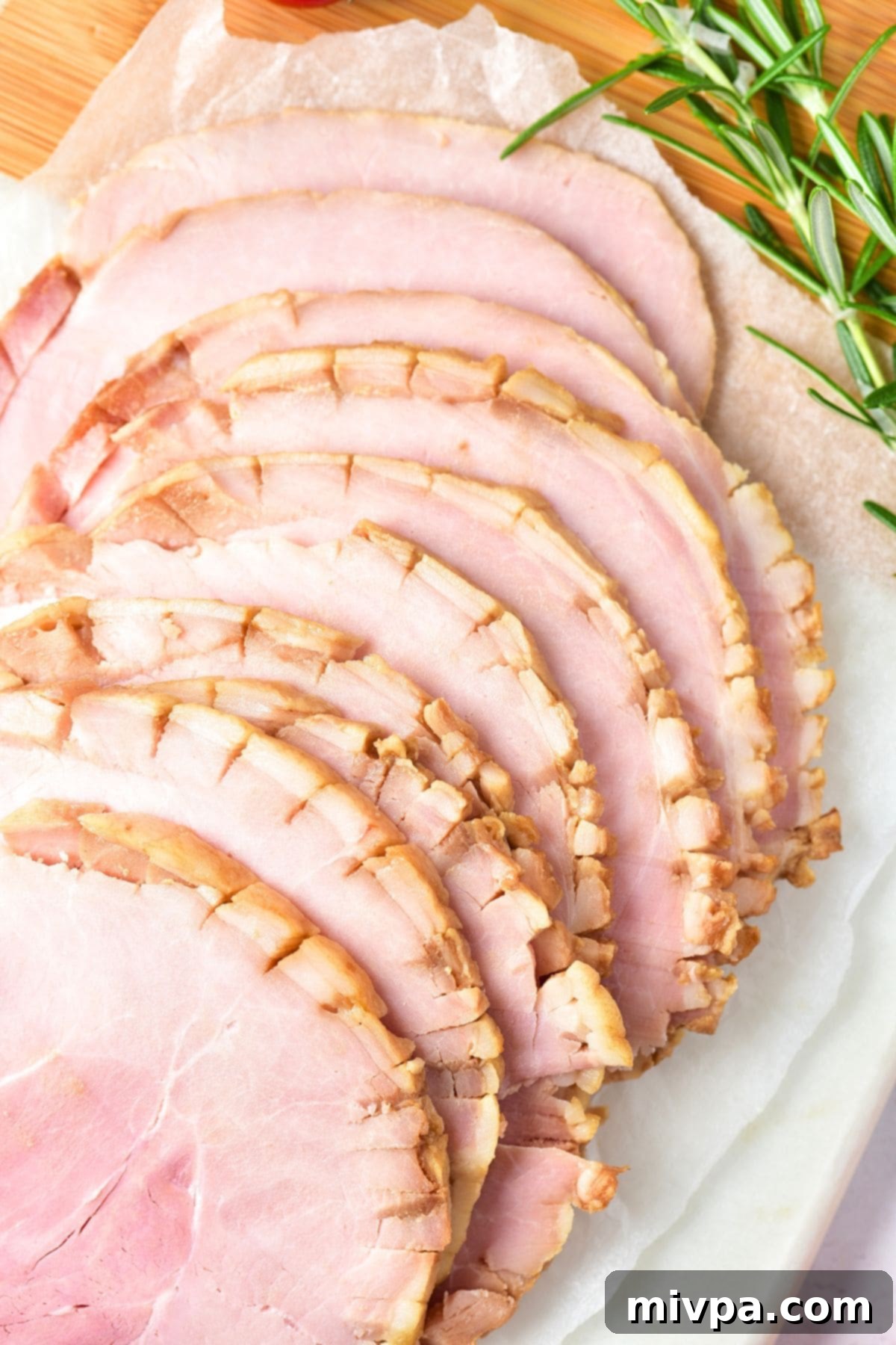 Top down view of sliced ham and rosemary