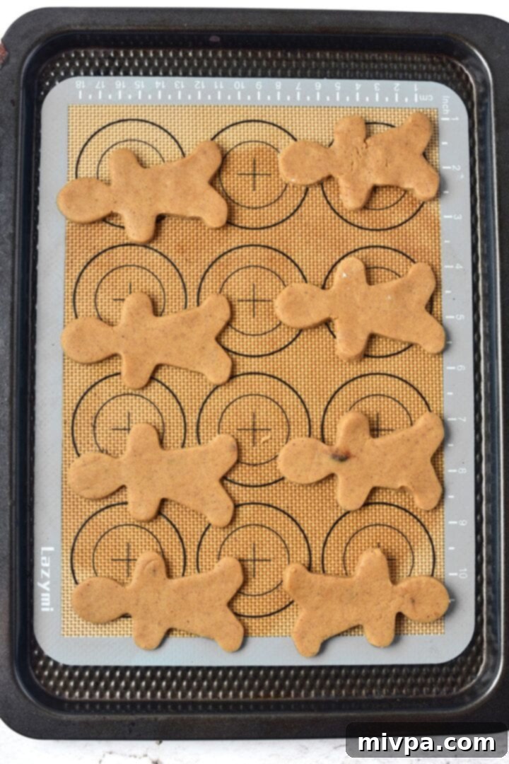 Easy Gluten-Free Gingerbread Men (Dairy-Free) Cut out cookie dough on silpat, ready for baking.