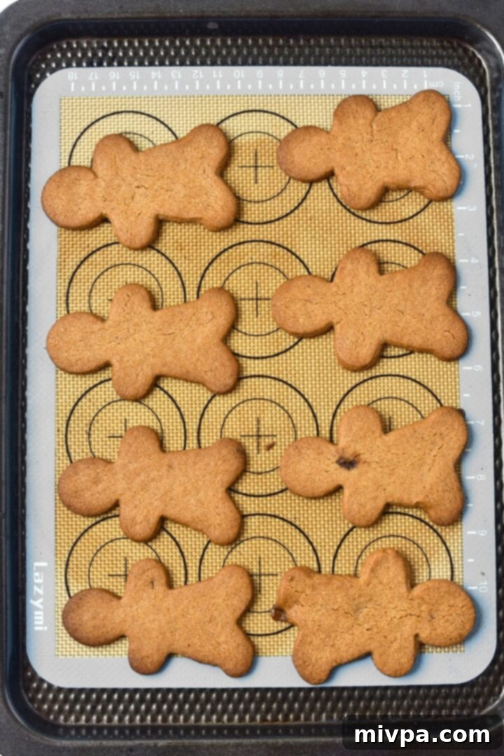 Easy Gluten-Free Dairy-Free Gingerbread Men (Dairy-Free) Freshly baked gingerbread men on silpat, showing their golden brown perfection.